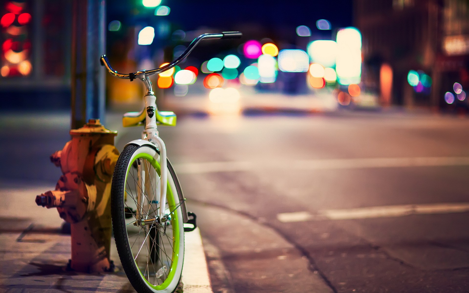 Bicycle parked next to a fire hydrant at night HD Wallpaper