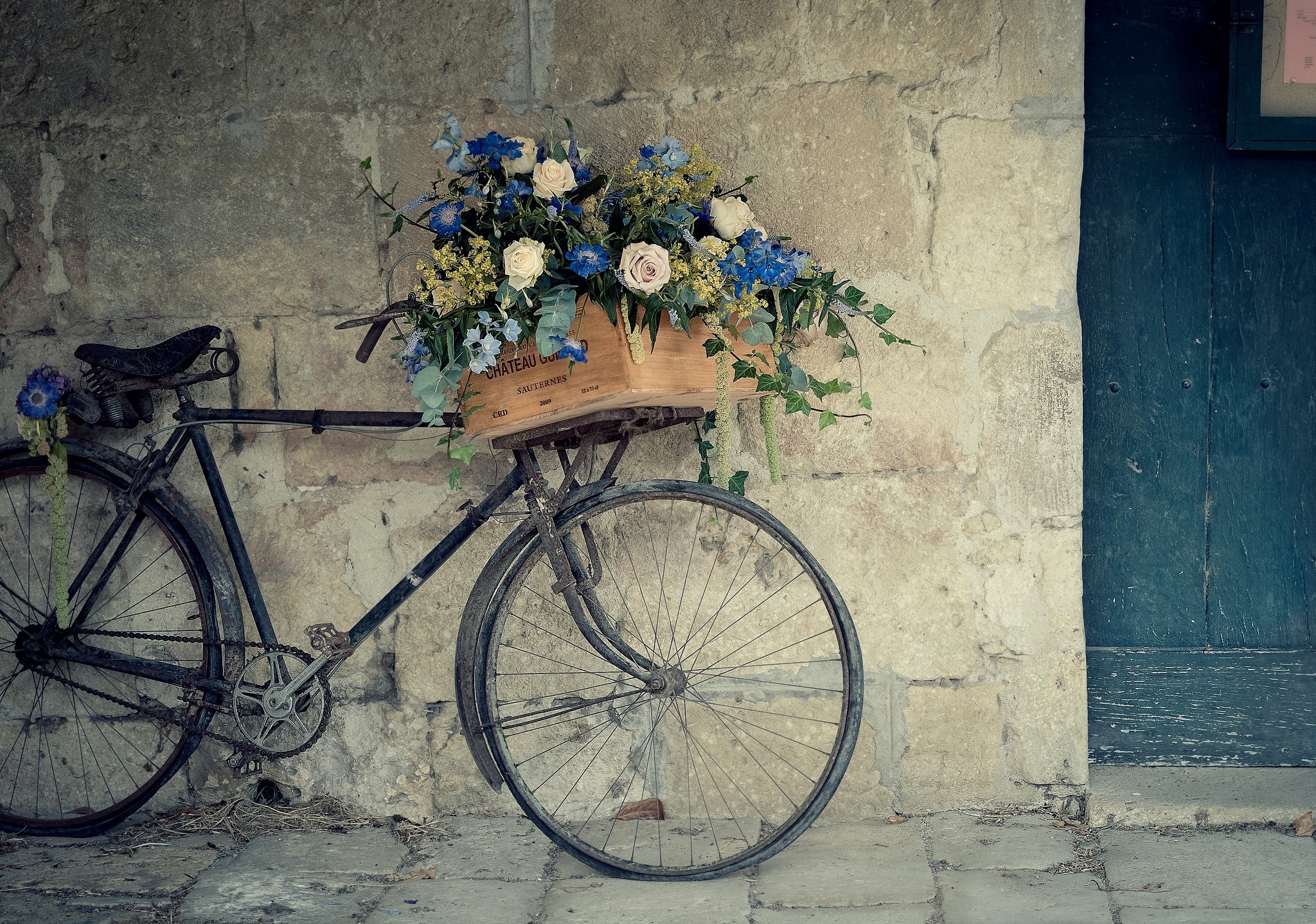 Old bicycle with flowers against a stone wall HD Wallpaper