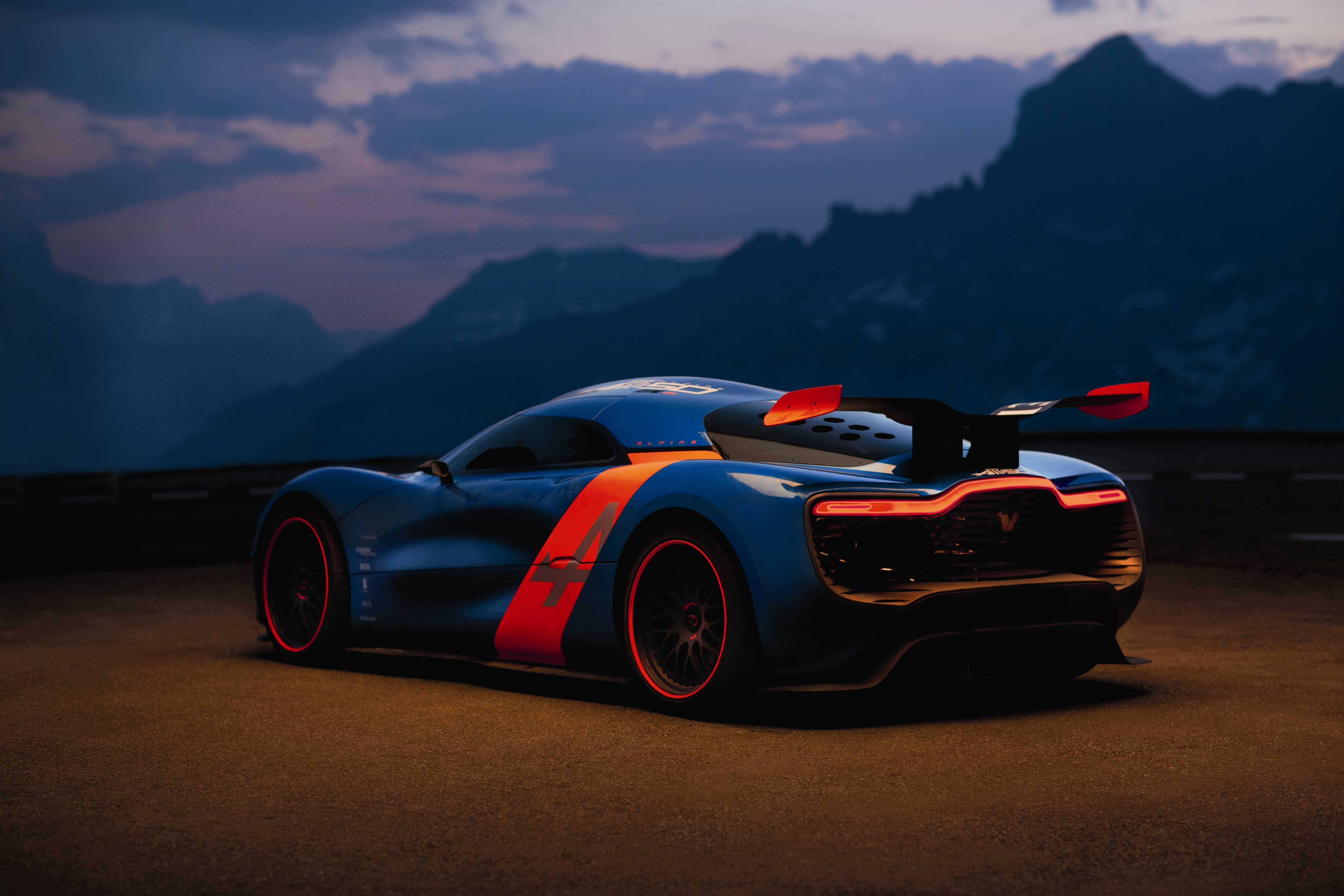 Blue Alpine A110-50 with orange stripe in mountains HD Wallpaper