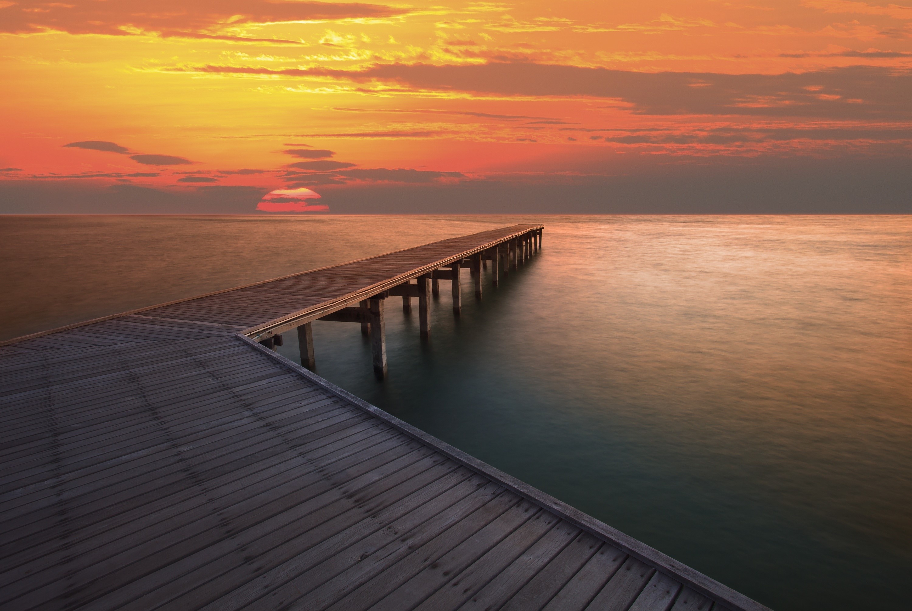 Wooden pier at sunset over the ocean HD Wallpaper