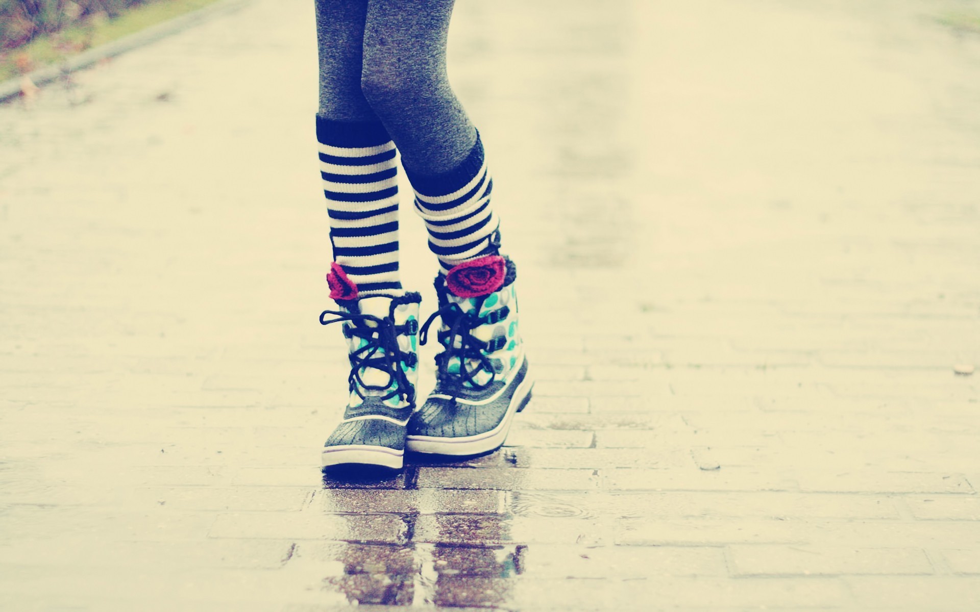 Legs in striped socks and patterned boots on wet pavement HD Wallpaper