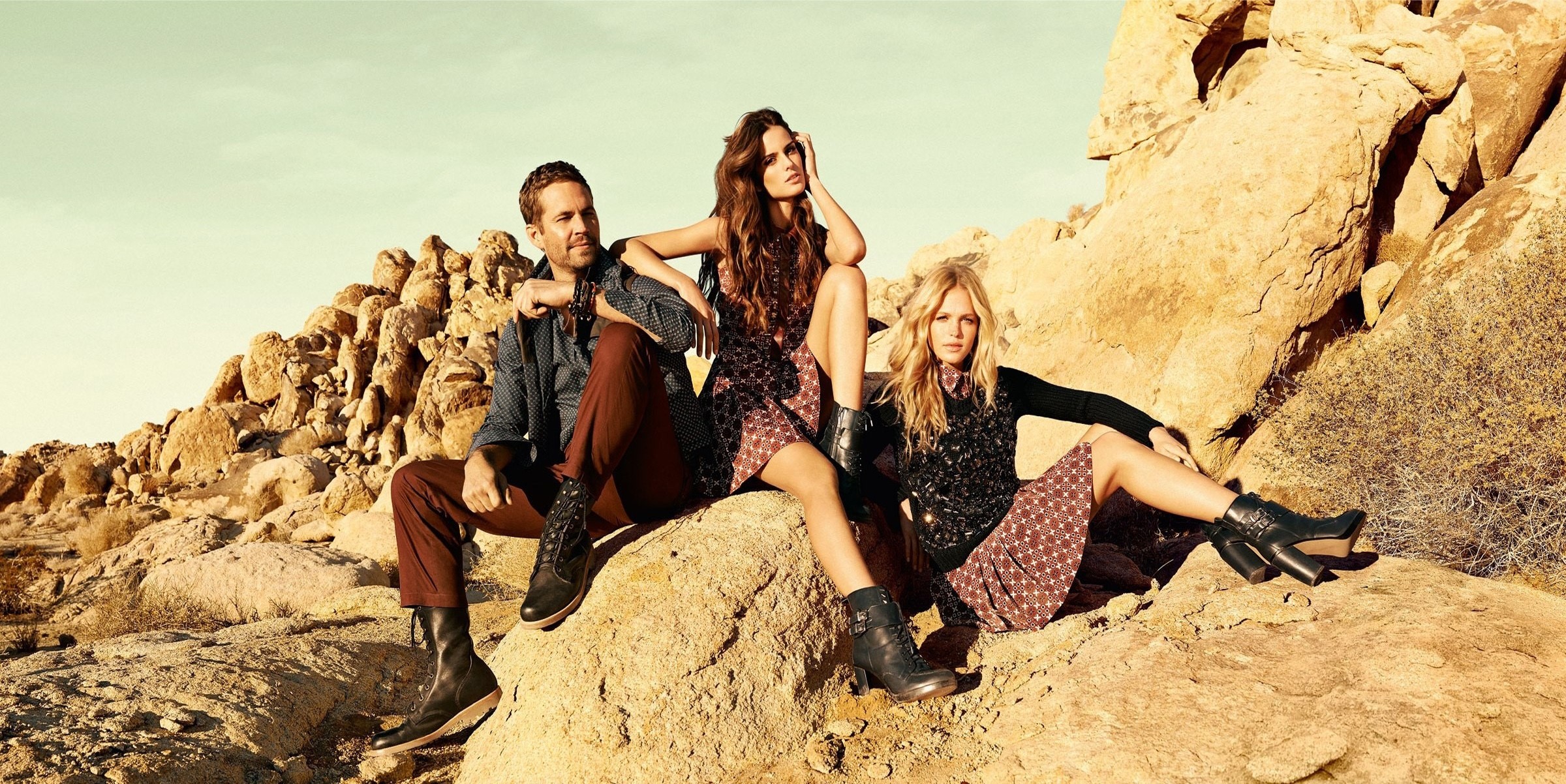 Paul Walker and two women sitting on rocks HD Wallpaper