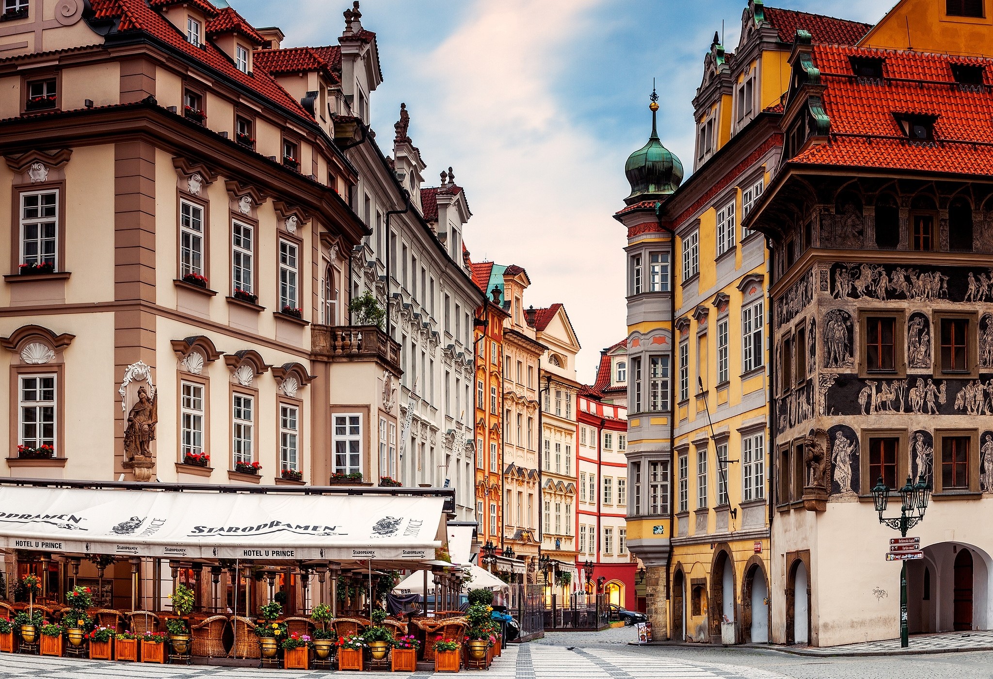 Prague street with historic buildings and outdoor cafe HD Wallpaper