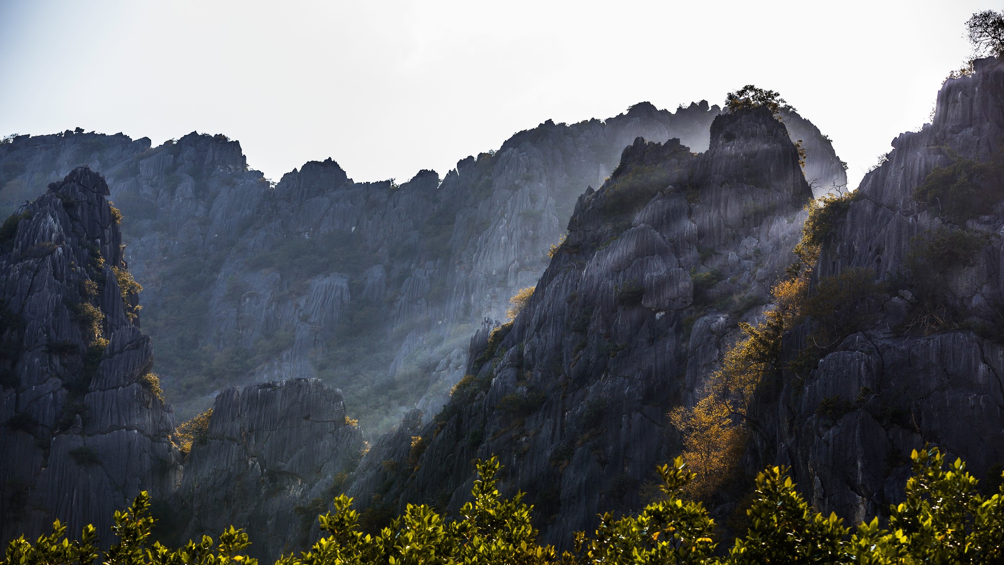 Jagged mountain peaks with sun rays in Thailand HD Wallpaper