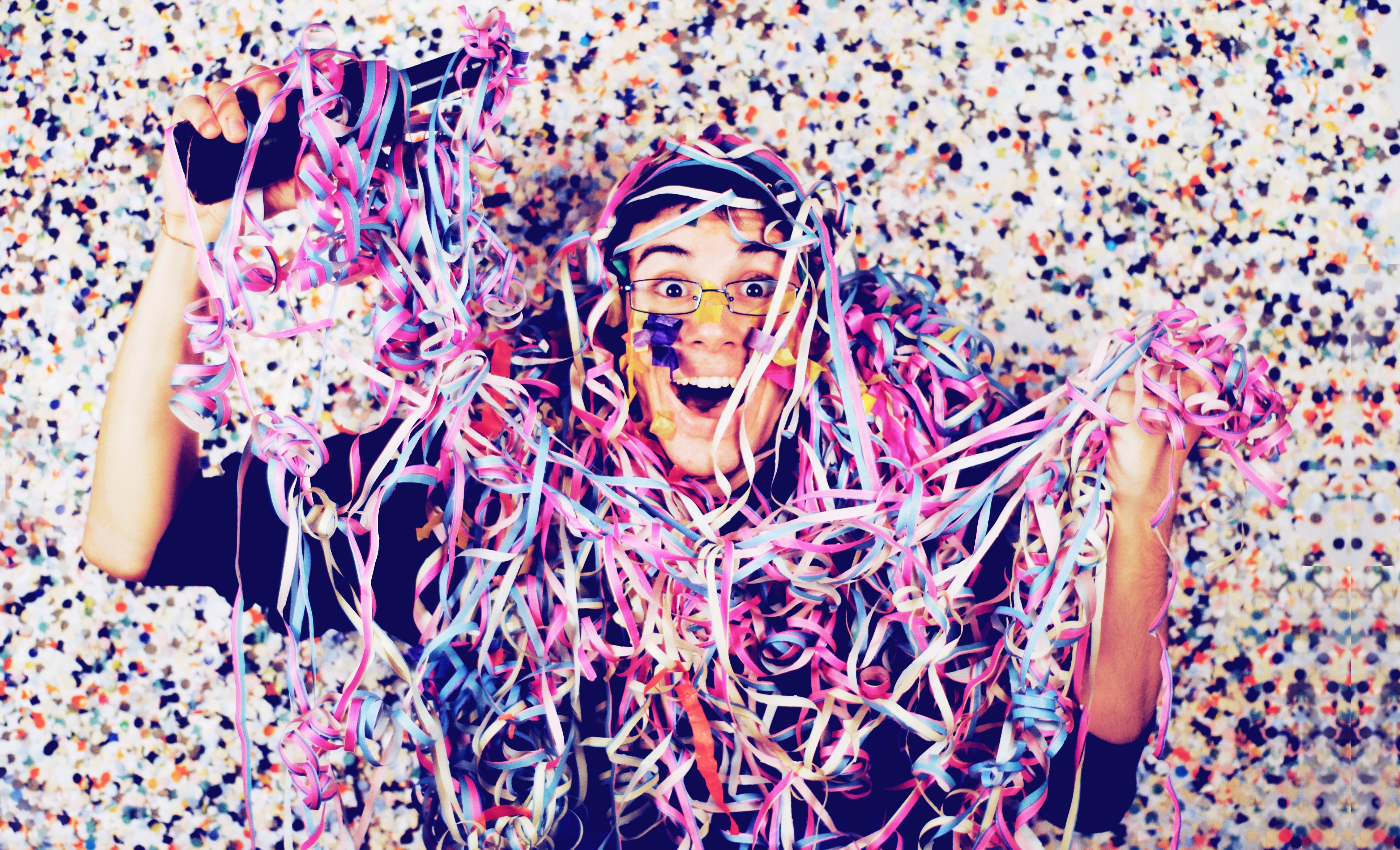 Man covered in colorful streamers and confetti HD Wallpaper