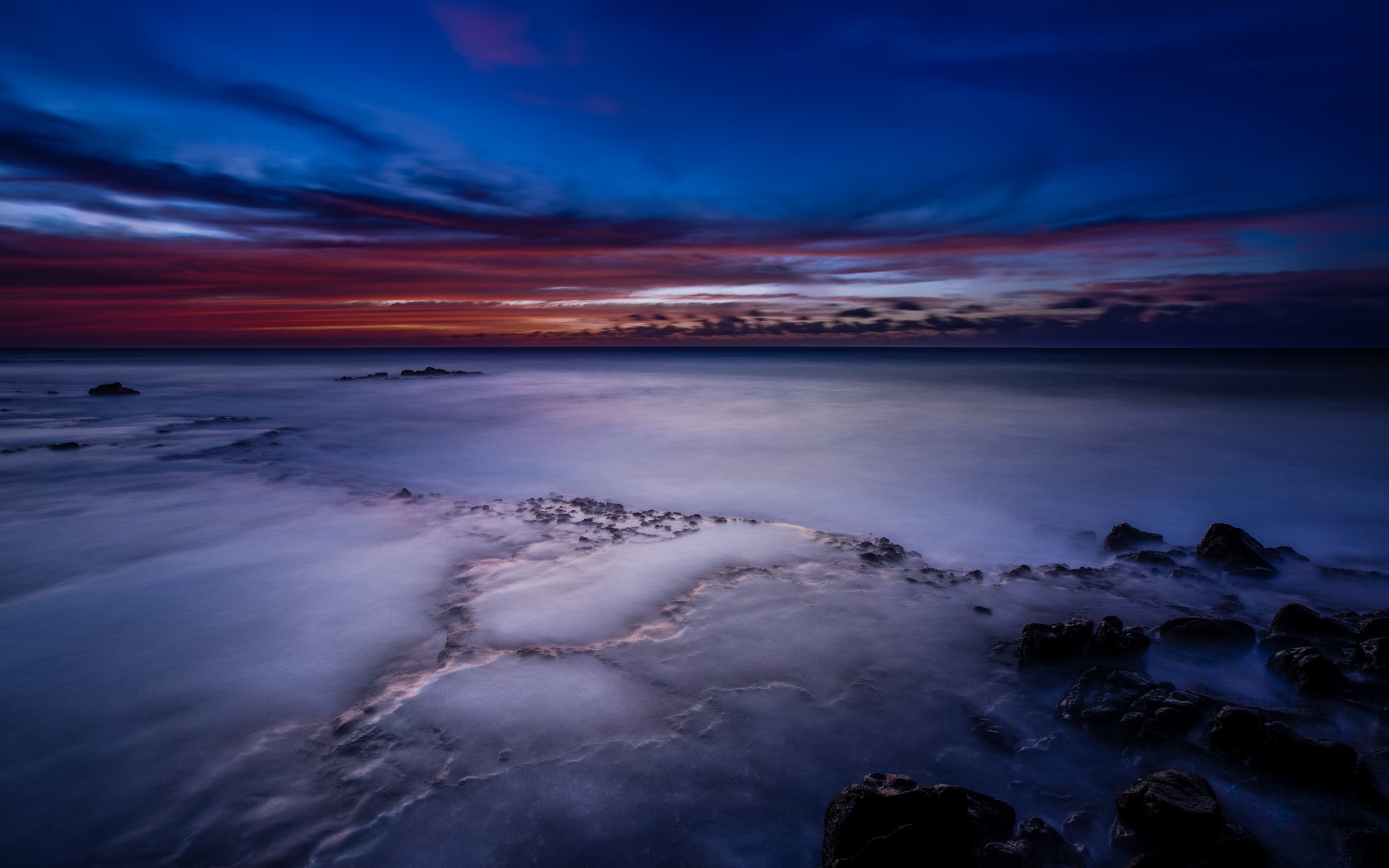 Ocean waves crashing on rocks at sunset in Hawaii HD Wallpaper