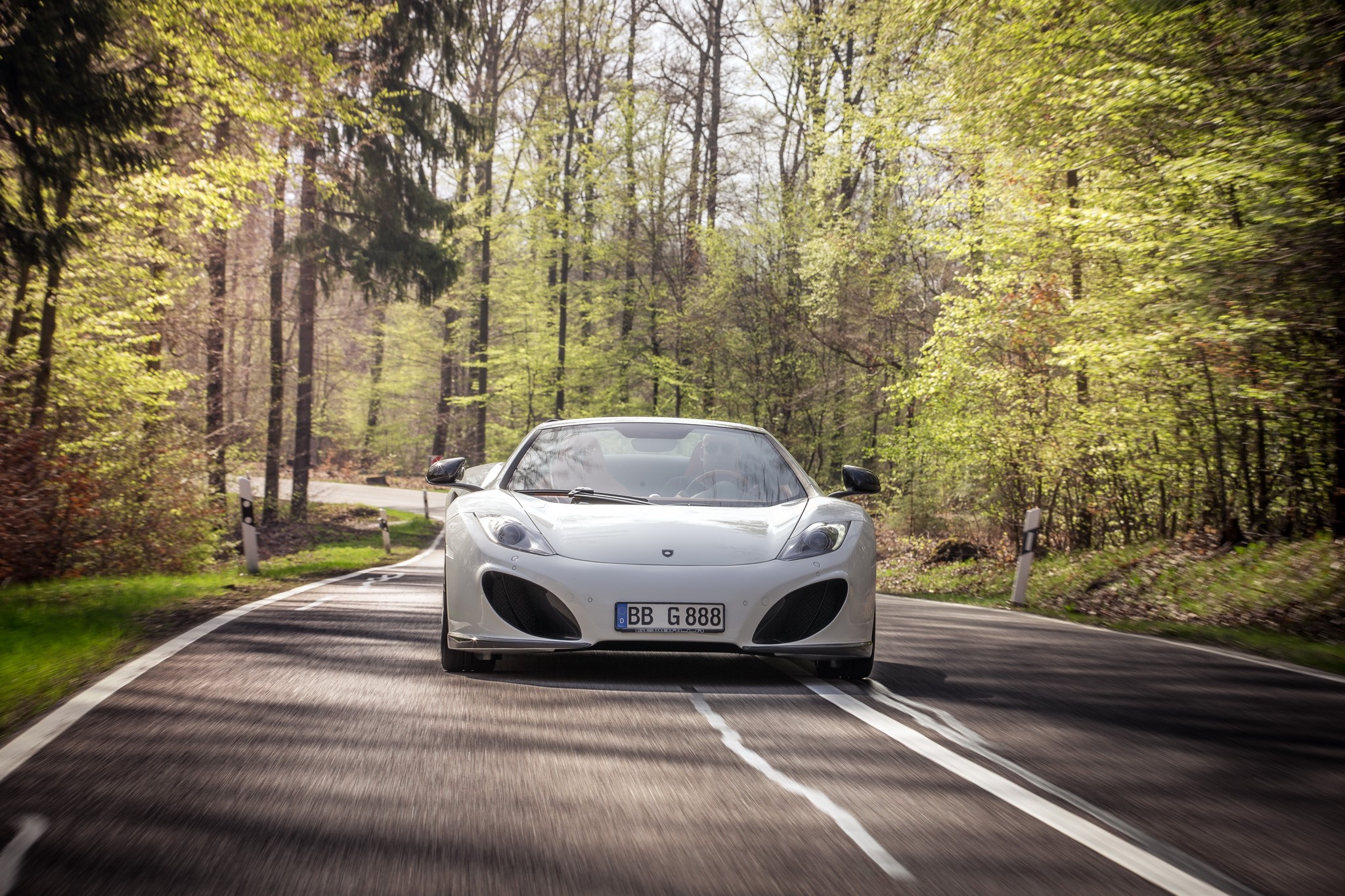 White McLaren 12C Spider driving on a forest road HD Wallpaper
