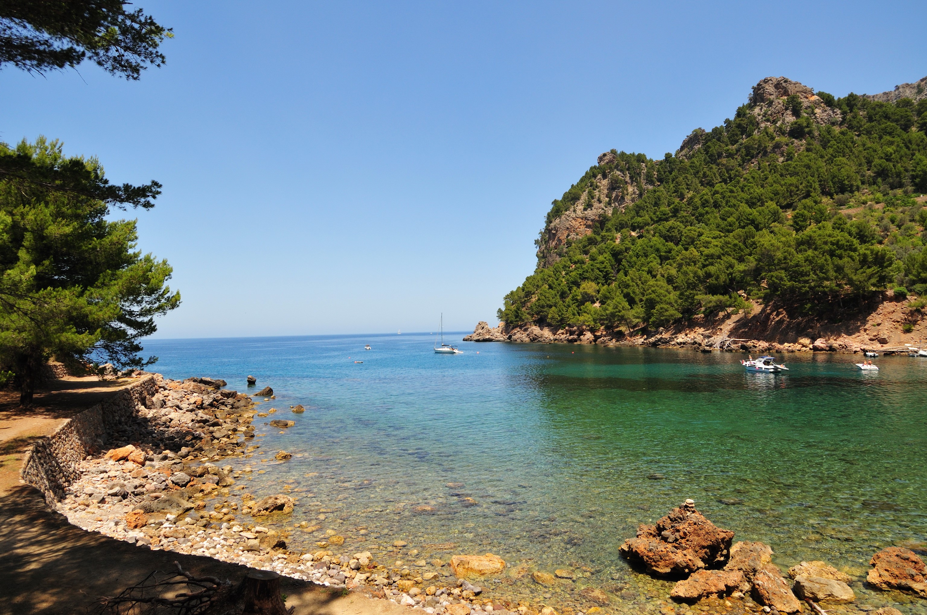 Bay with boats and forested mountains in Mallorca, Spain HD Wallpaper