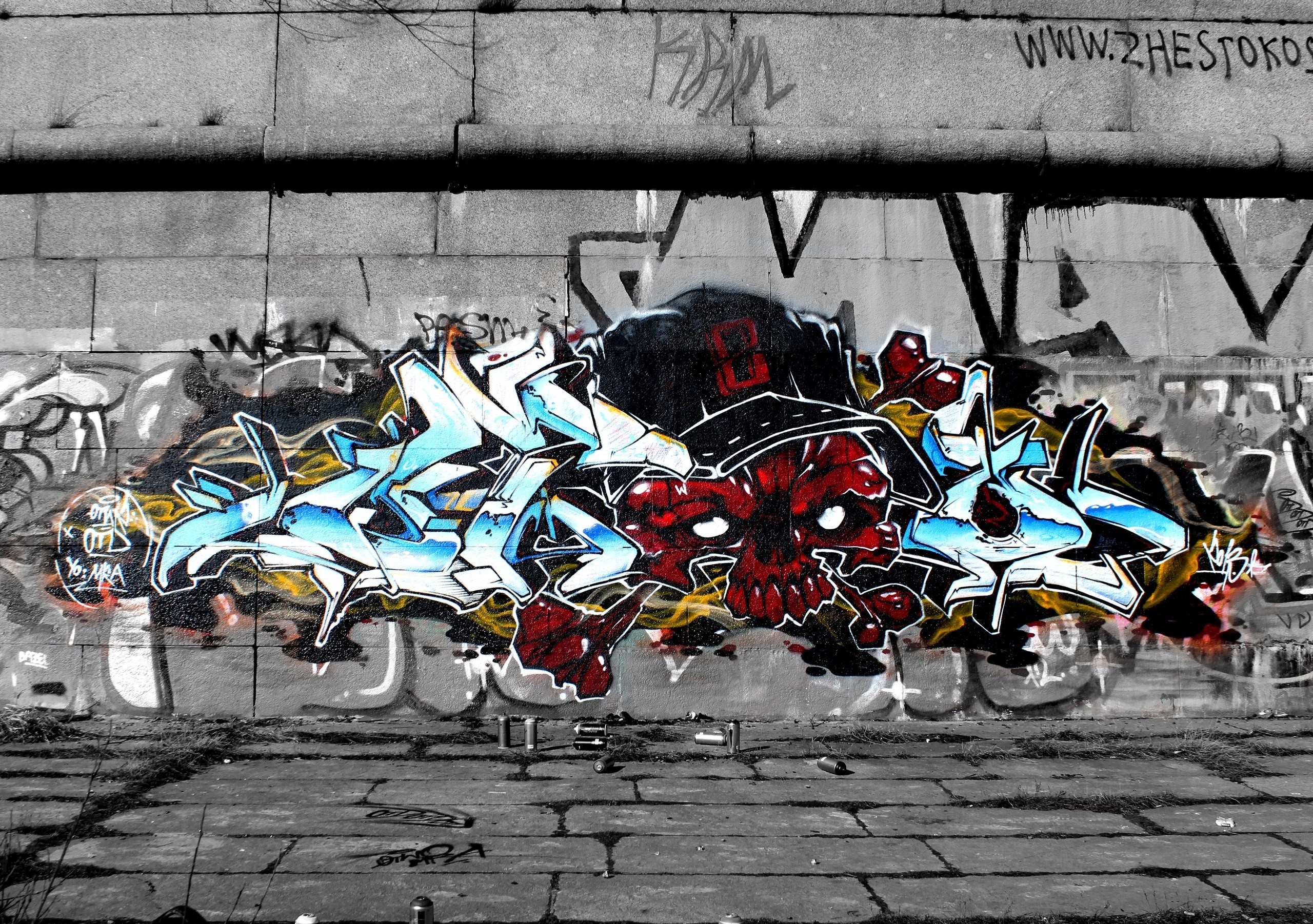 Graffiti art of a red skull and blue lettering on a wall HD Wallpaper