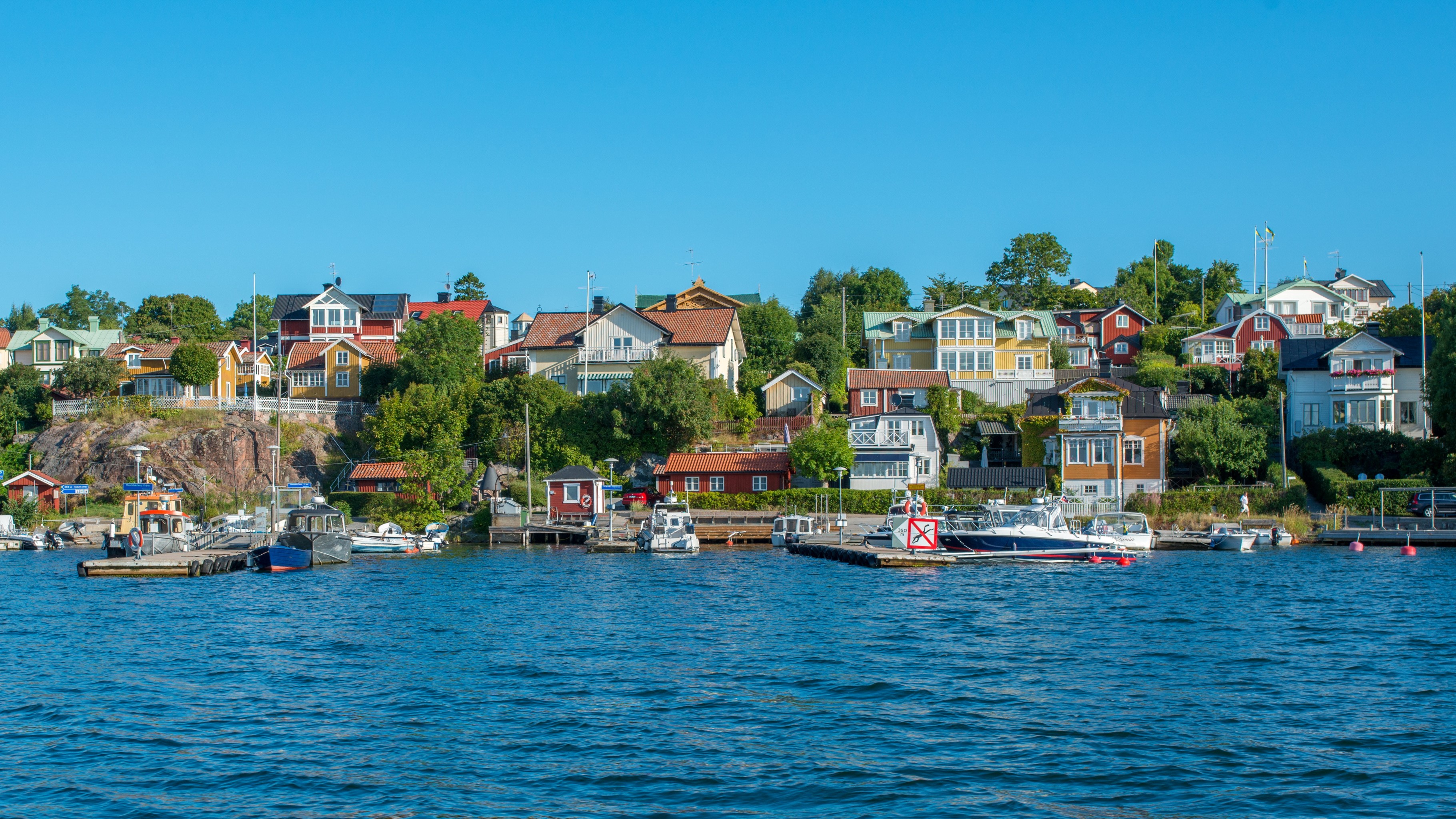 Houses on a hill overlooking a bay in Sweden HD Wallpaper