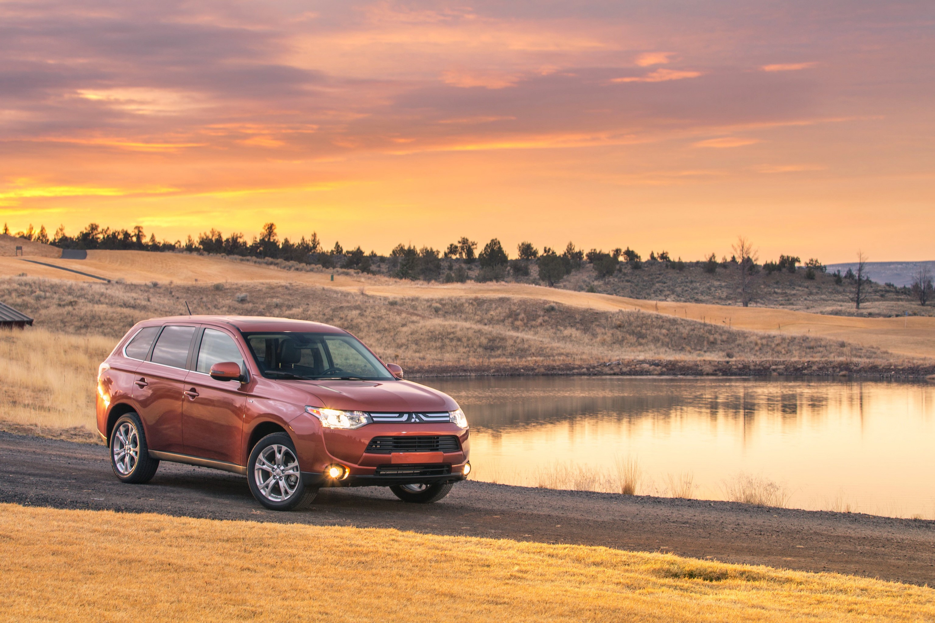 2014 Mitsubishi Outlander GT parked by a lake at sunset HD Wallpaper