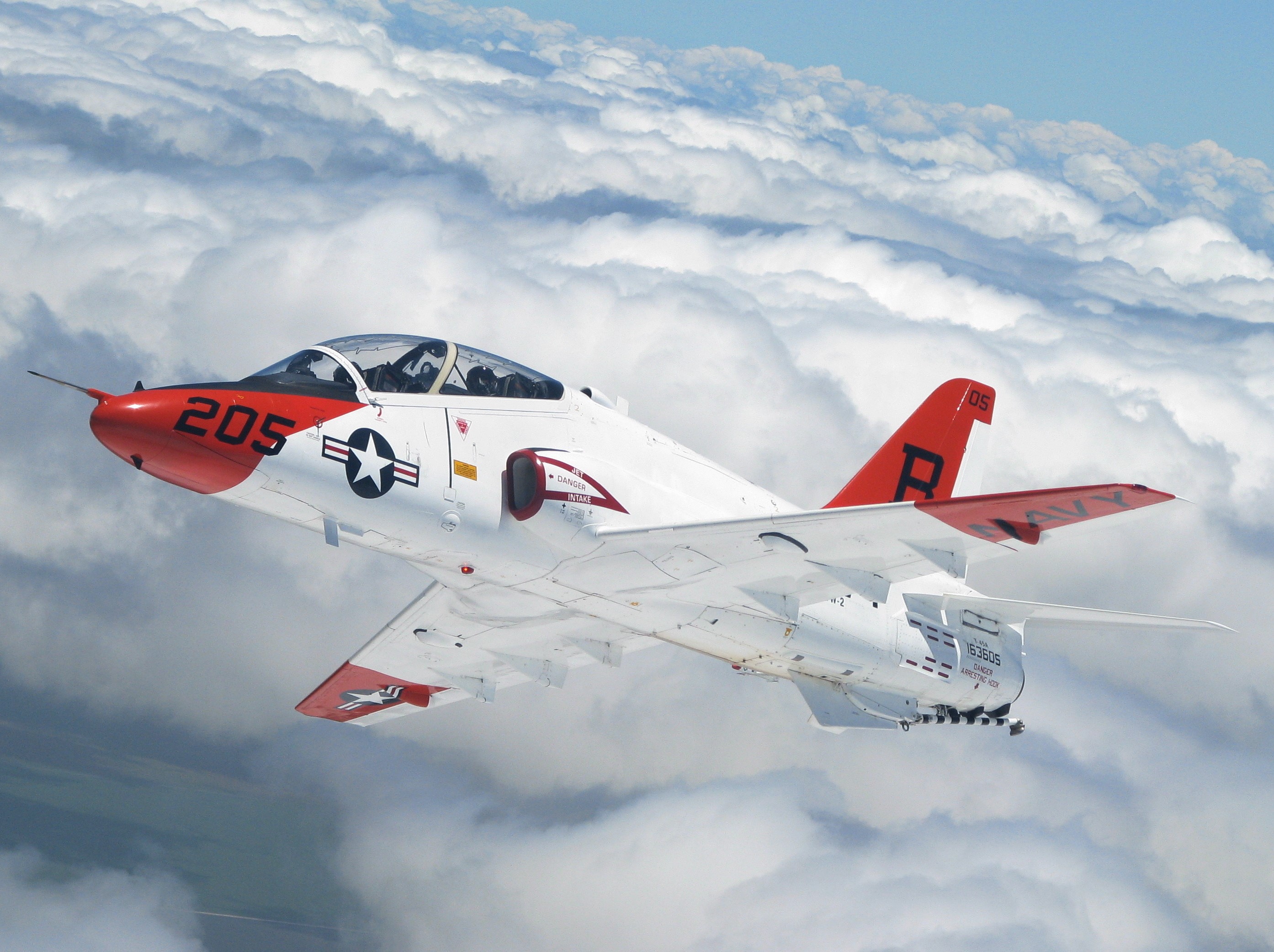 T-45 Goshawk jet trainer flying above clouds HD Wallpaper