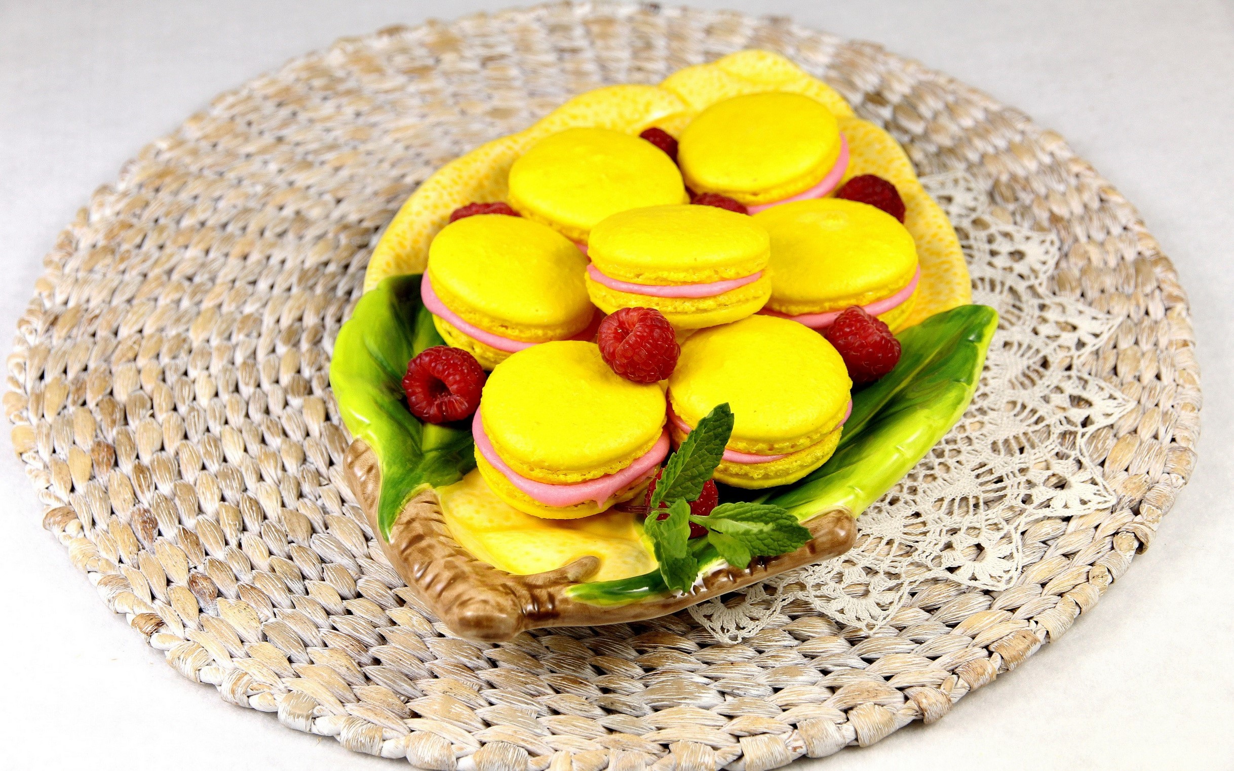 Yellow macarons with raspberries on a decorative plate HD Wallpaper
