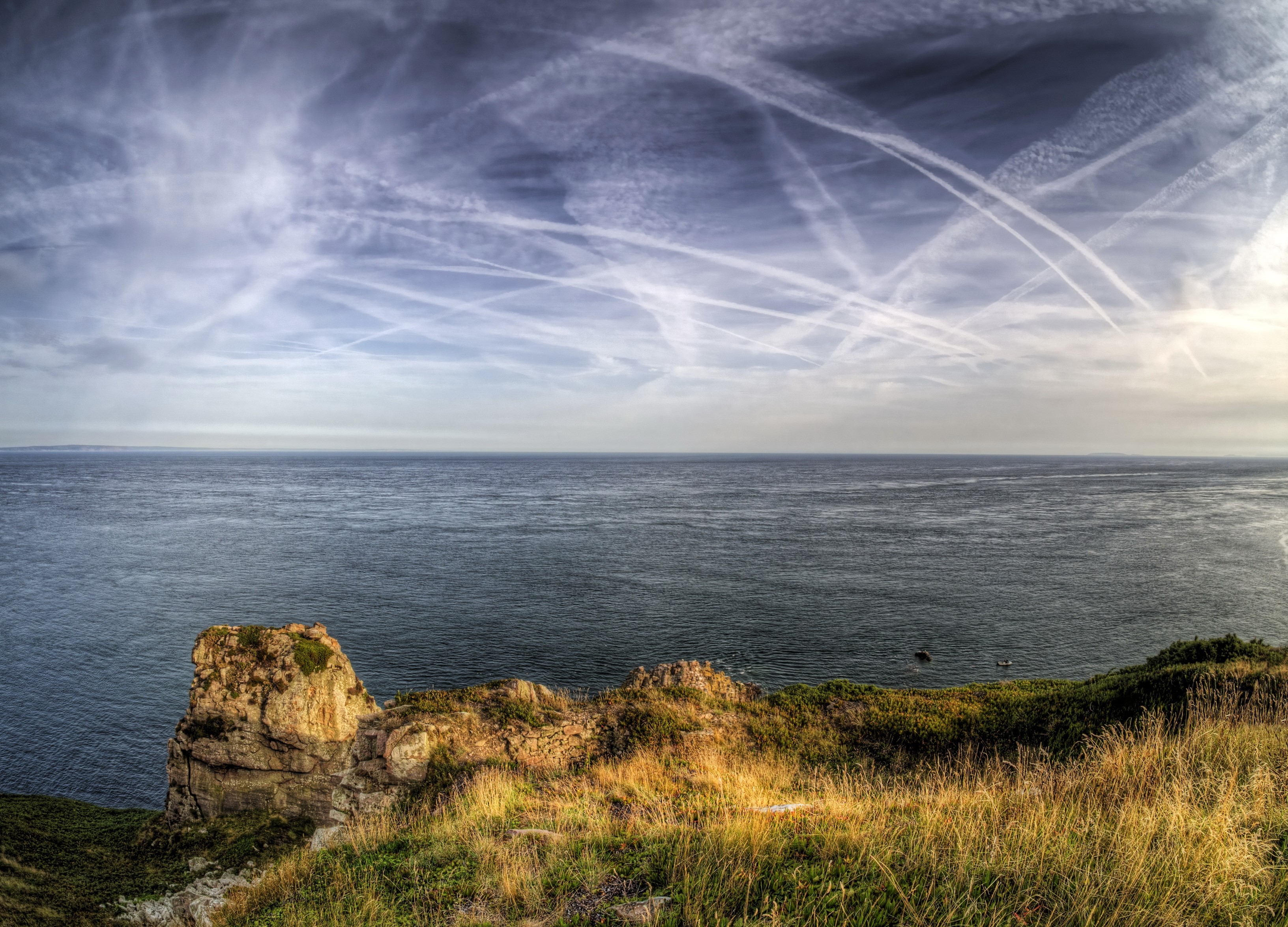 Coastline with ocean and sky with contrails HD Wallpaper