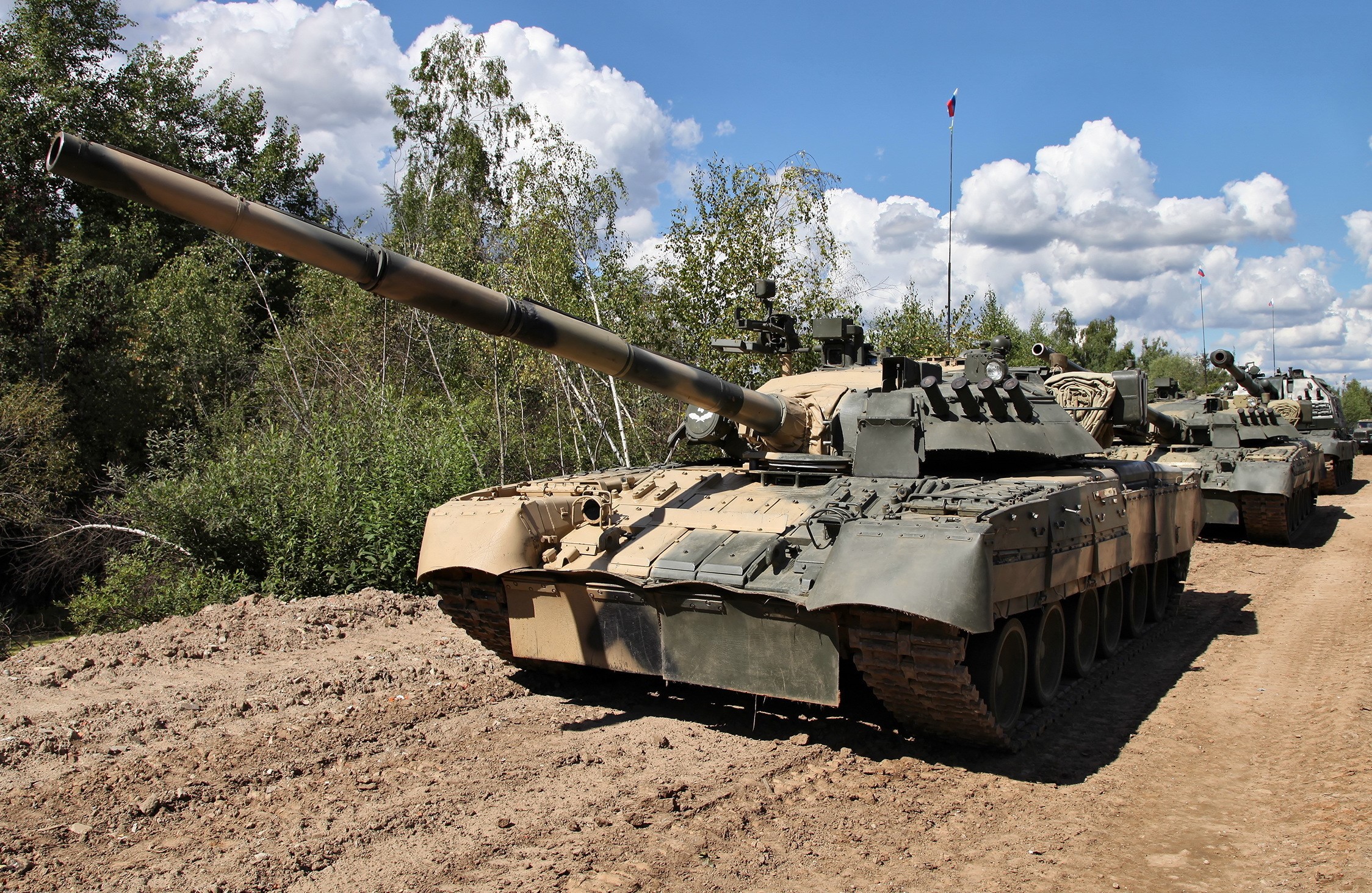 T-80 UD tanks in a line on a dirt road HD Wallpaper