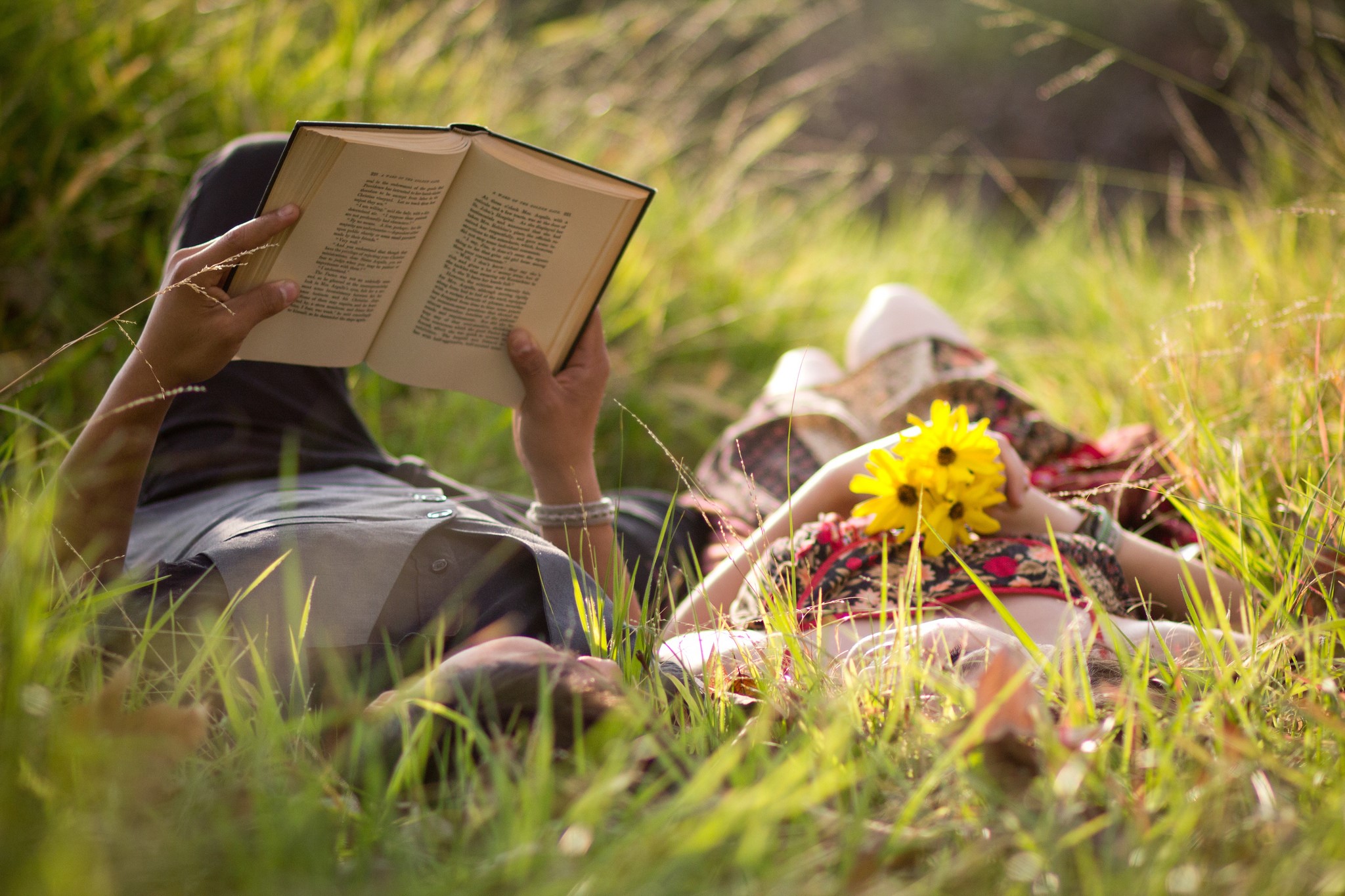 Two people reading and relaxing in grass HD Wallpaper