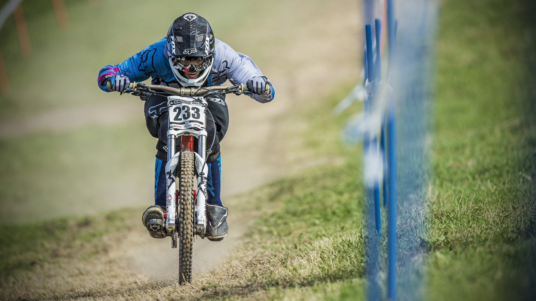 Man in racing gear riding a downhill mountain bike HD Wallpaper