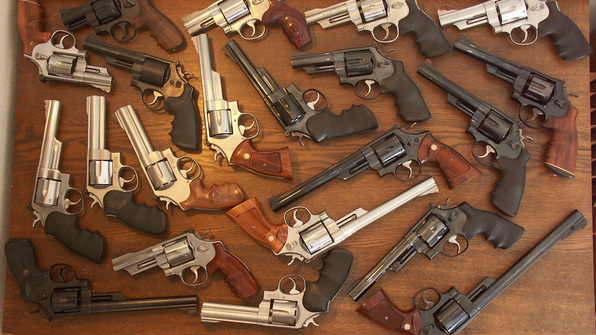 Many revolvers on a wooden surface HD Wallpaper