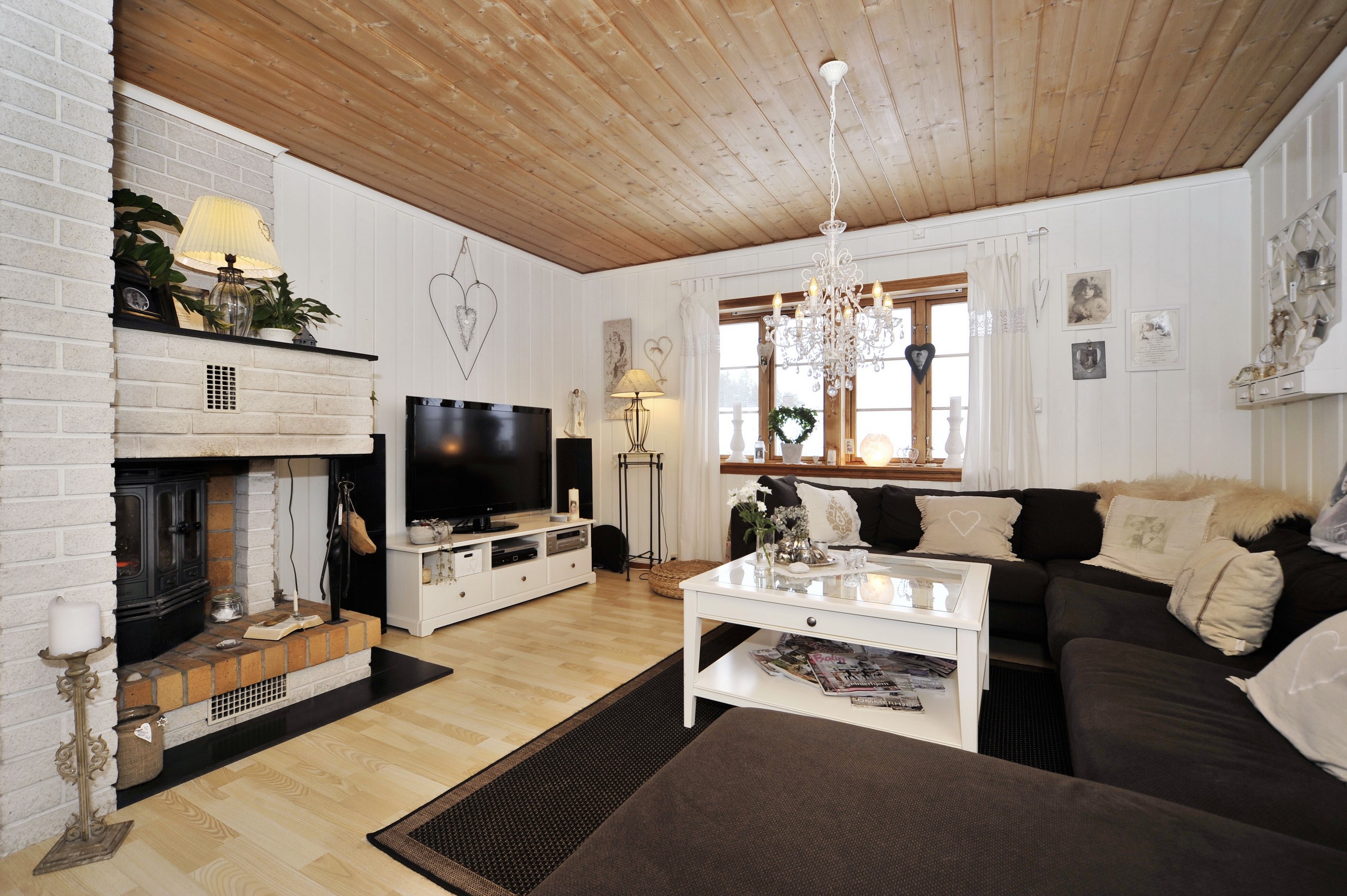 Living room with fireplace, sofa, and chandelier HD Wallpaper