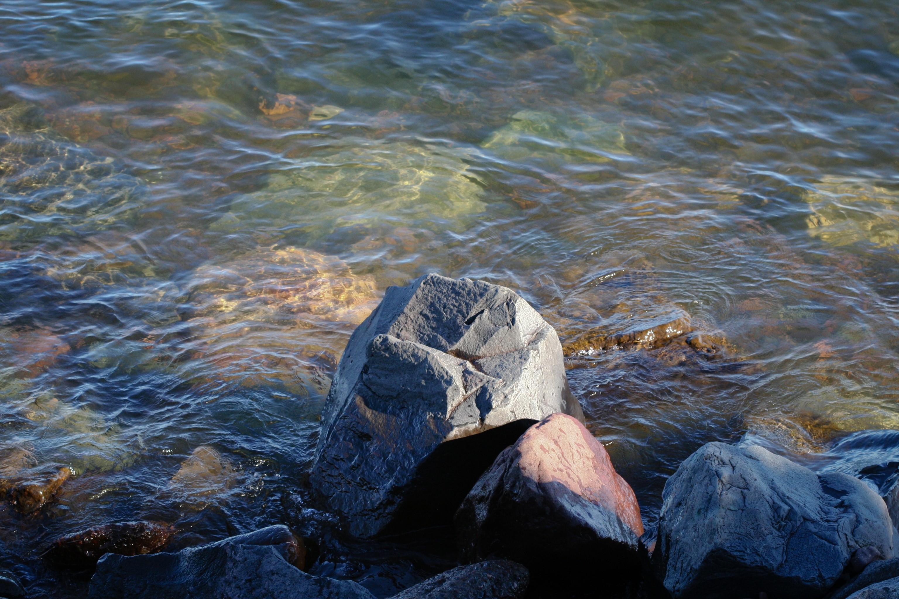 Rocks and clear water on a sunny day HD Wallpaper