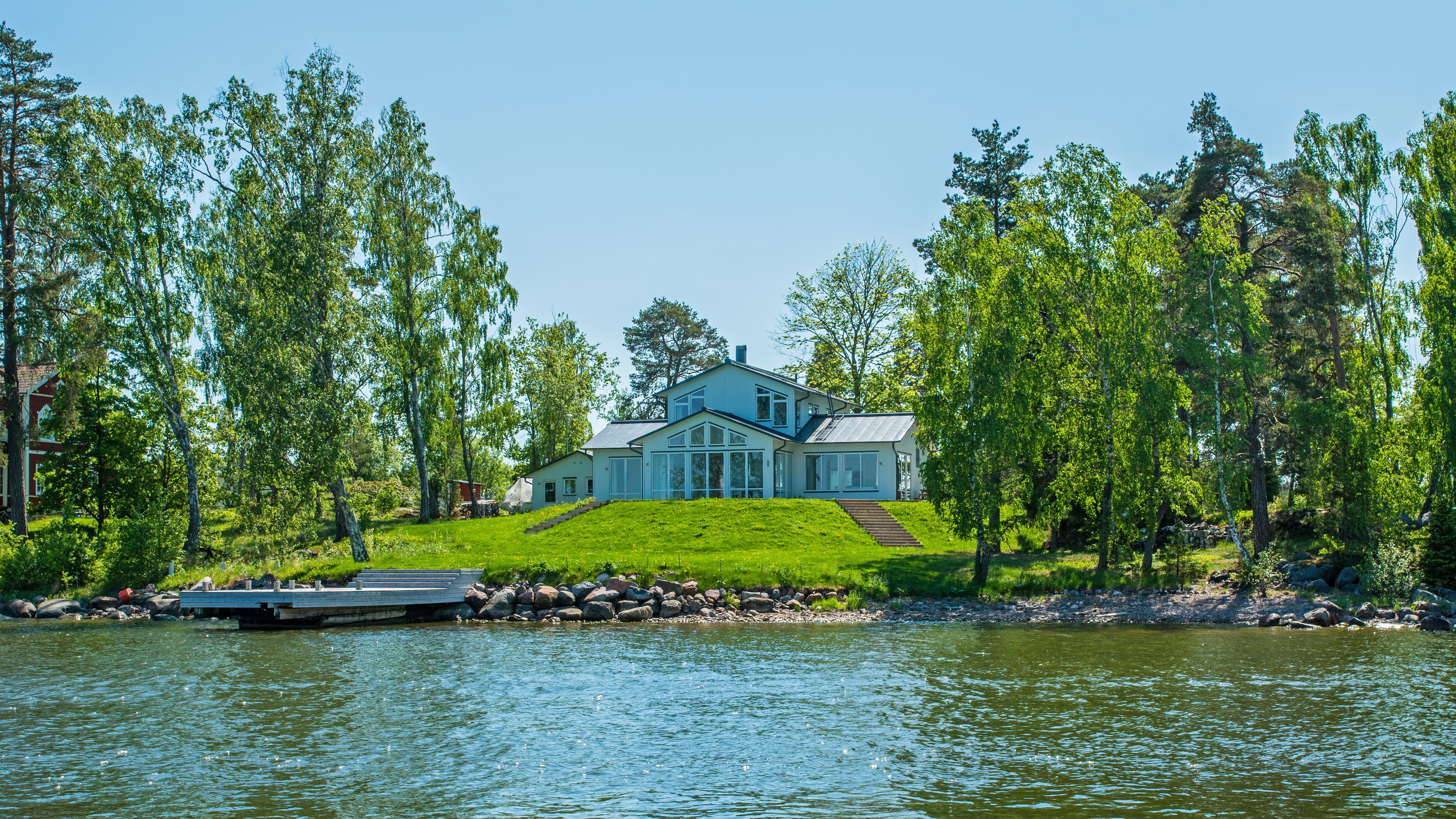 Modern house on a grassy hill by the water in Vaxholm, Sweden HD Wallpaper