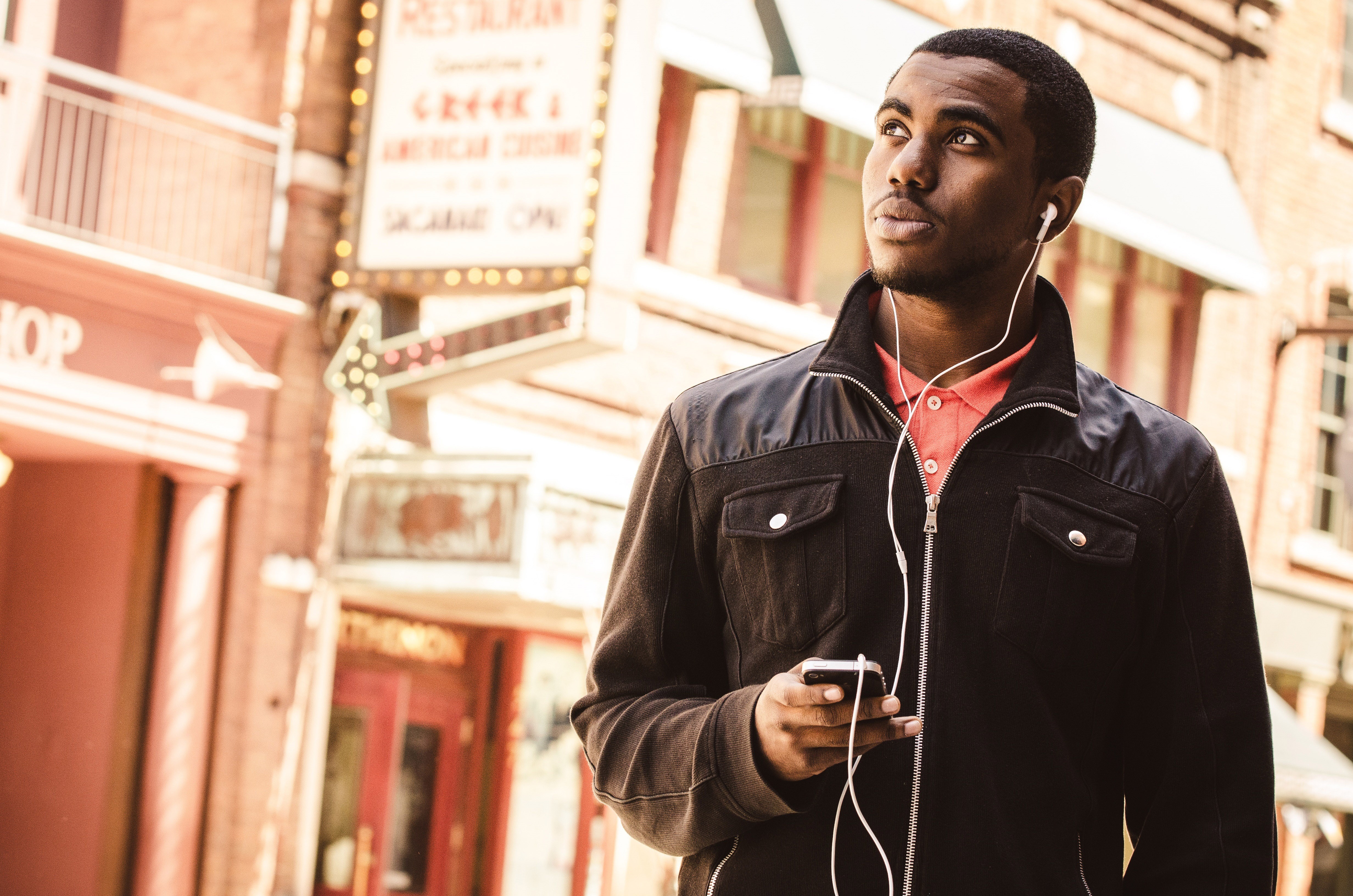 Man with headphones and phone on street HD Wallpaper