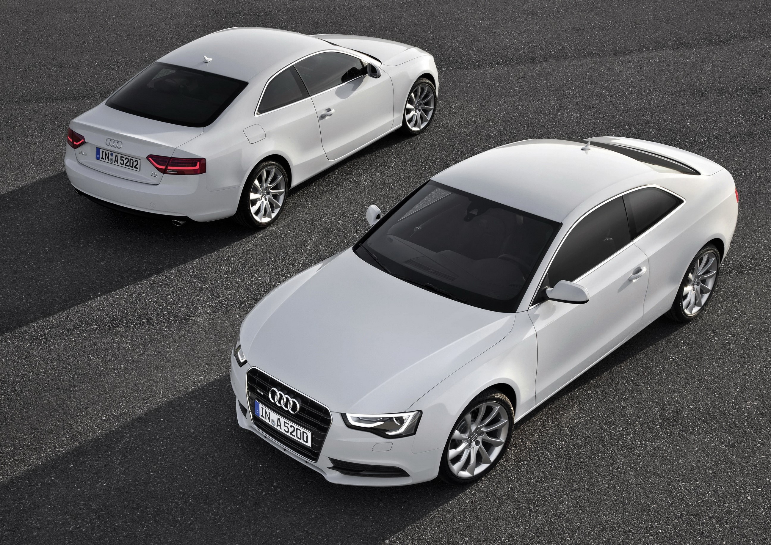 Two white Audi A5 Coupe cars on asphalt HD Wallpaper