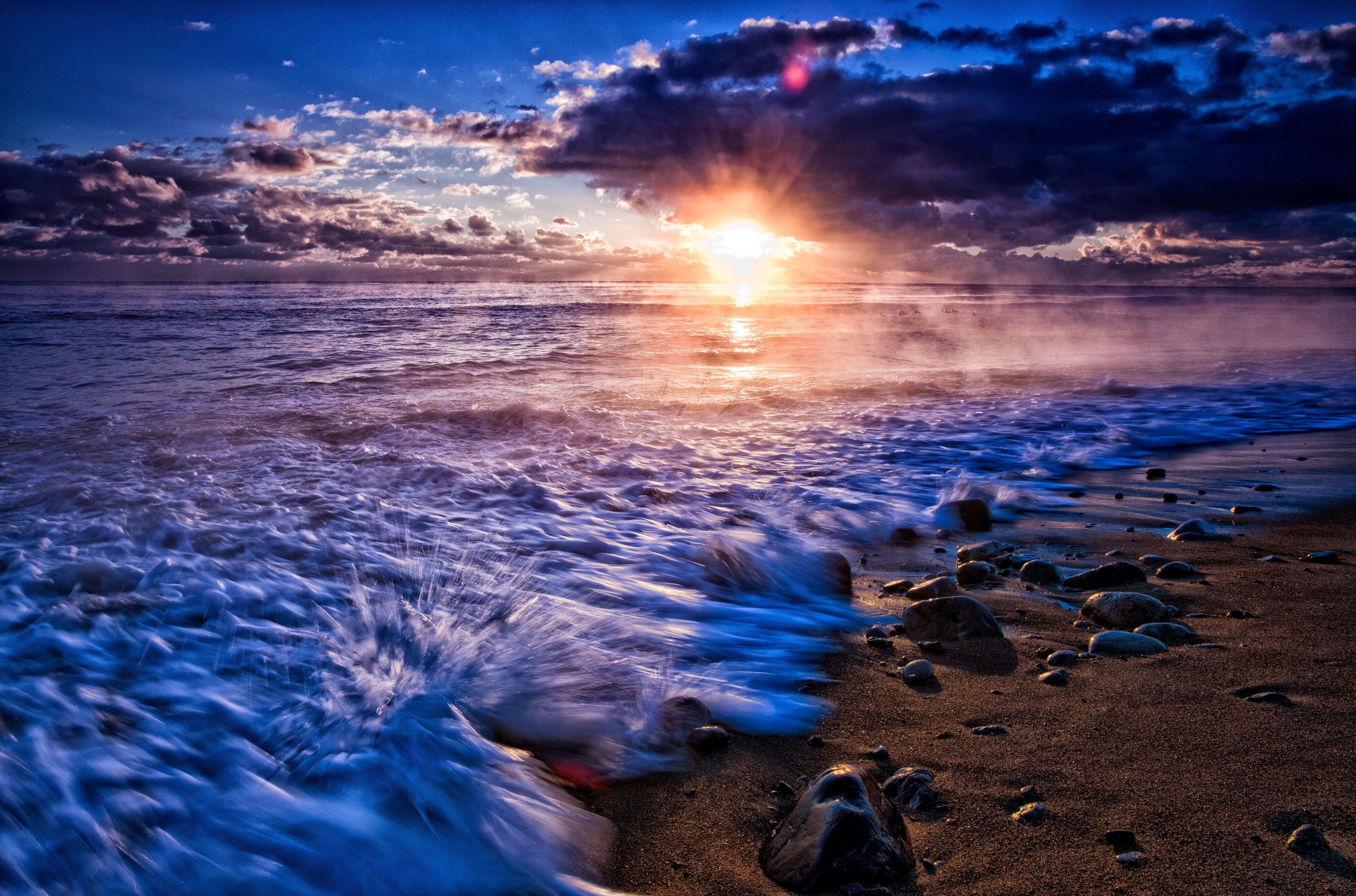 Sunset over the sea with waves crashing on the shore HD Wallpaper