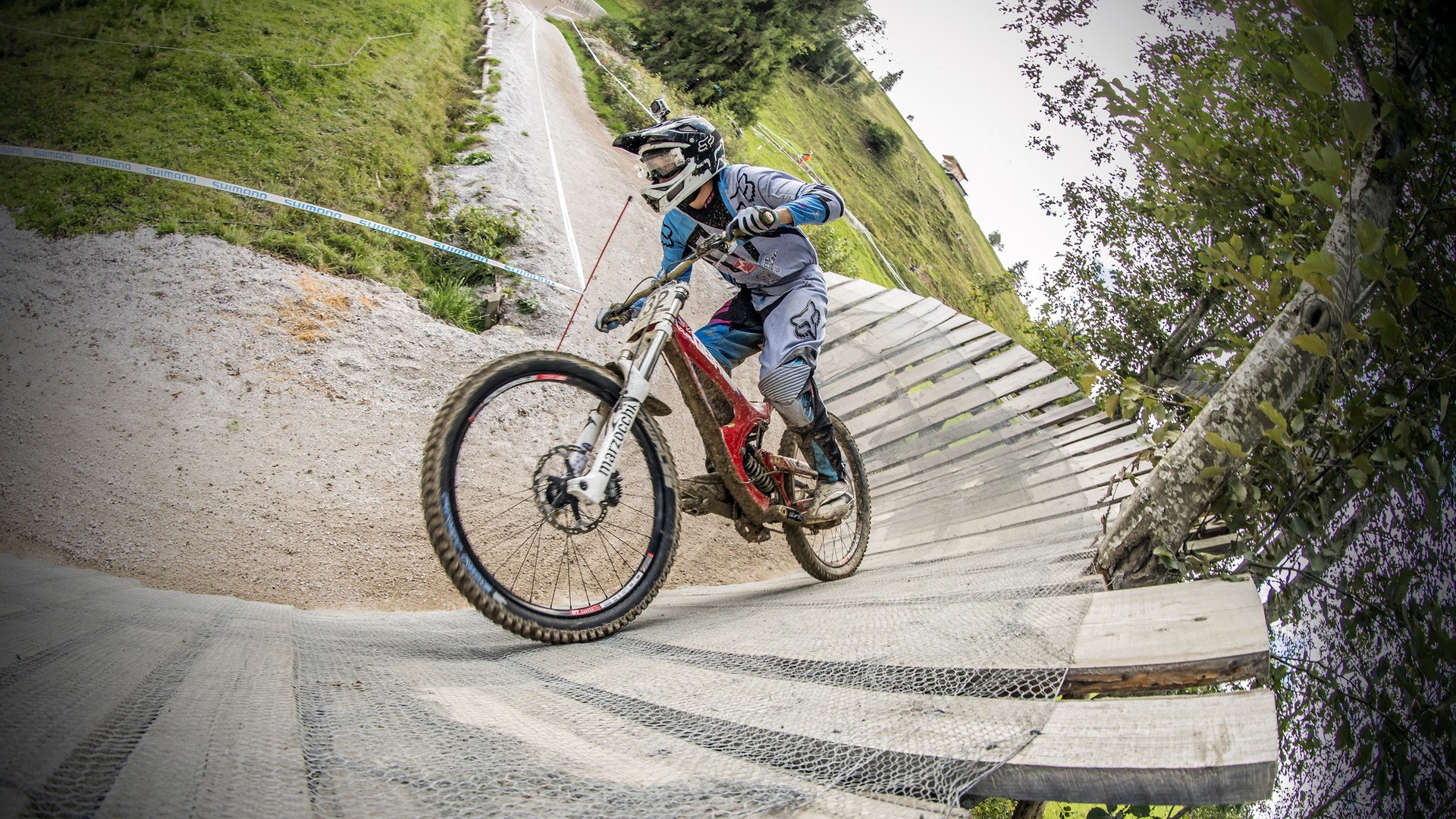 Downhill mountain biker on wooden ramp HD Wallpaper