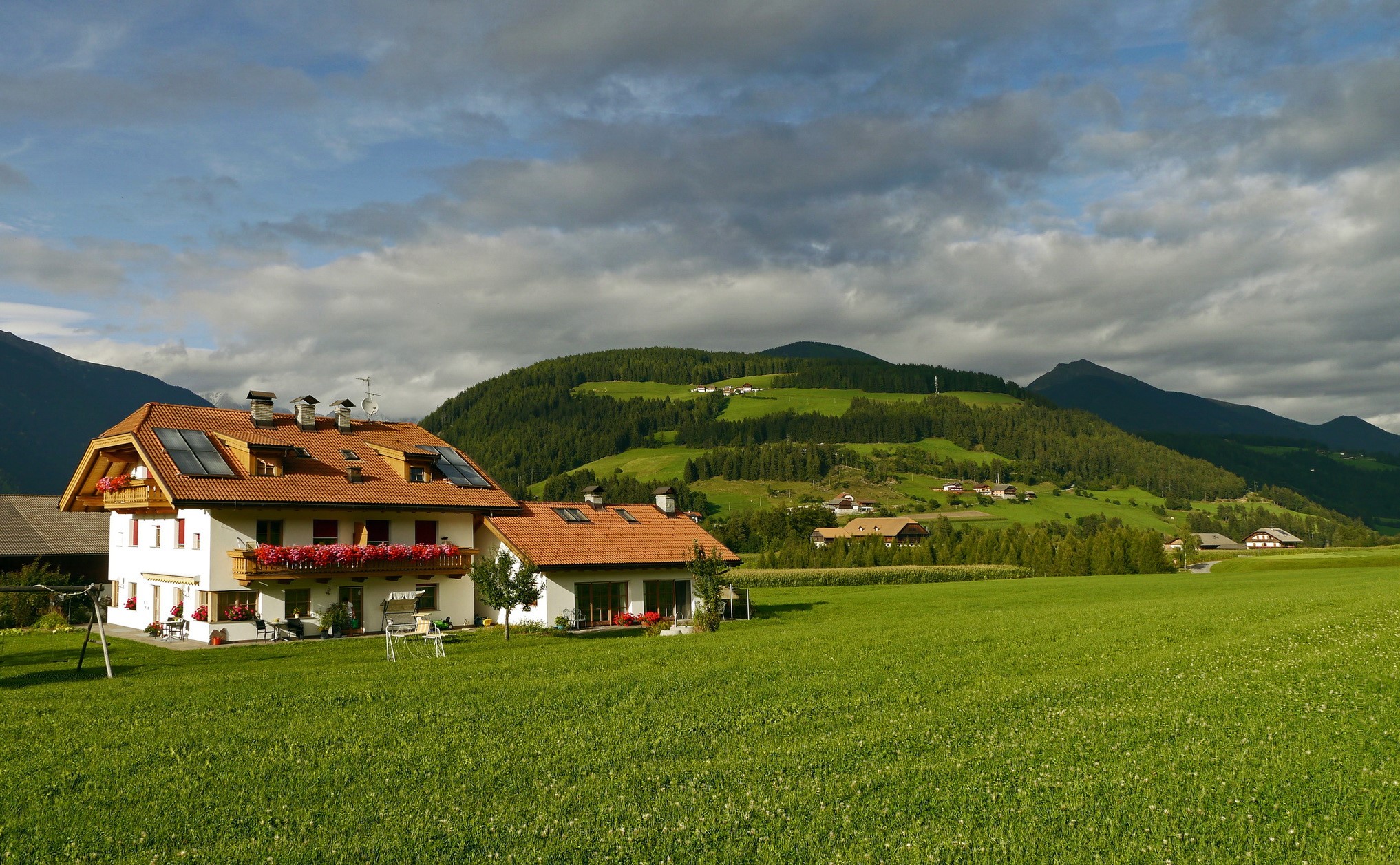 Houses in Valdaora, Italy with mountains and grasslands HD Wallpaper
