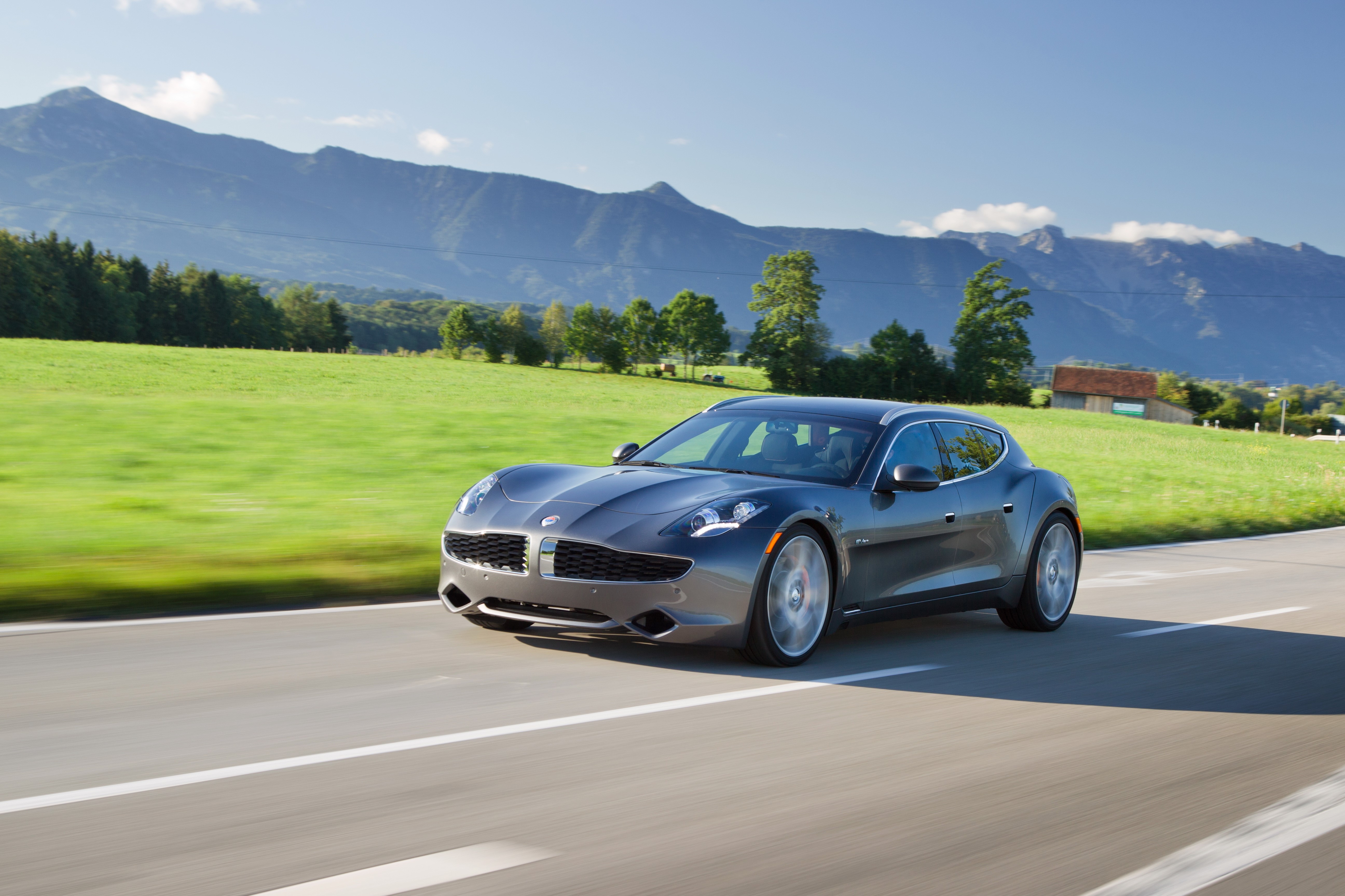 Grey Fisker Karma driving on a road with mountains HD Wallpaper