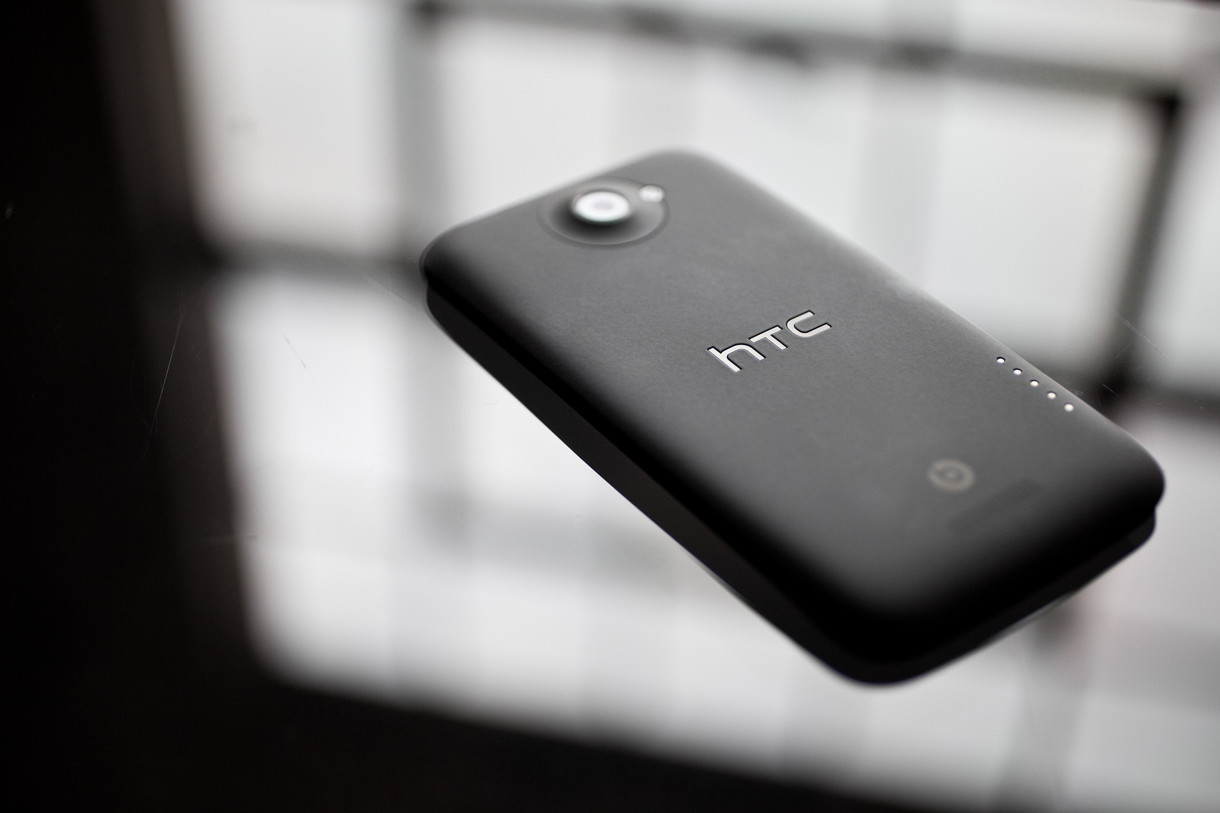 HTC One X smartphone on a reflective surface HD Wallpaper