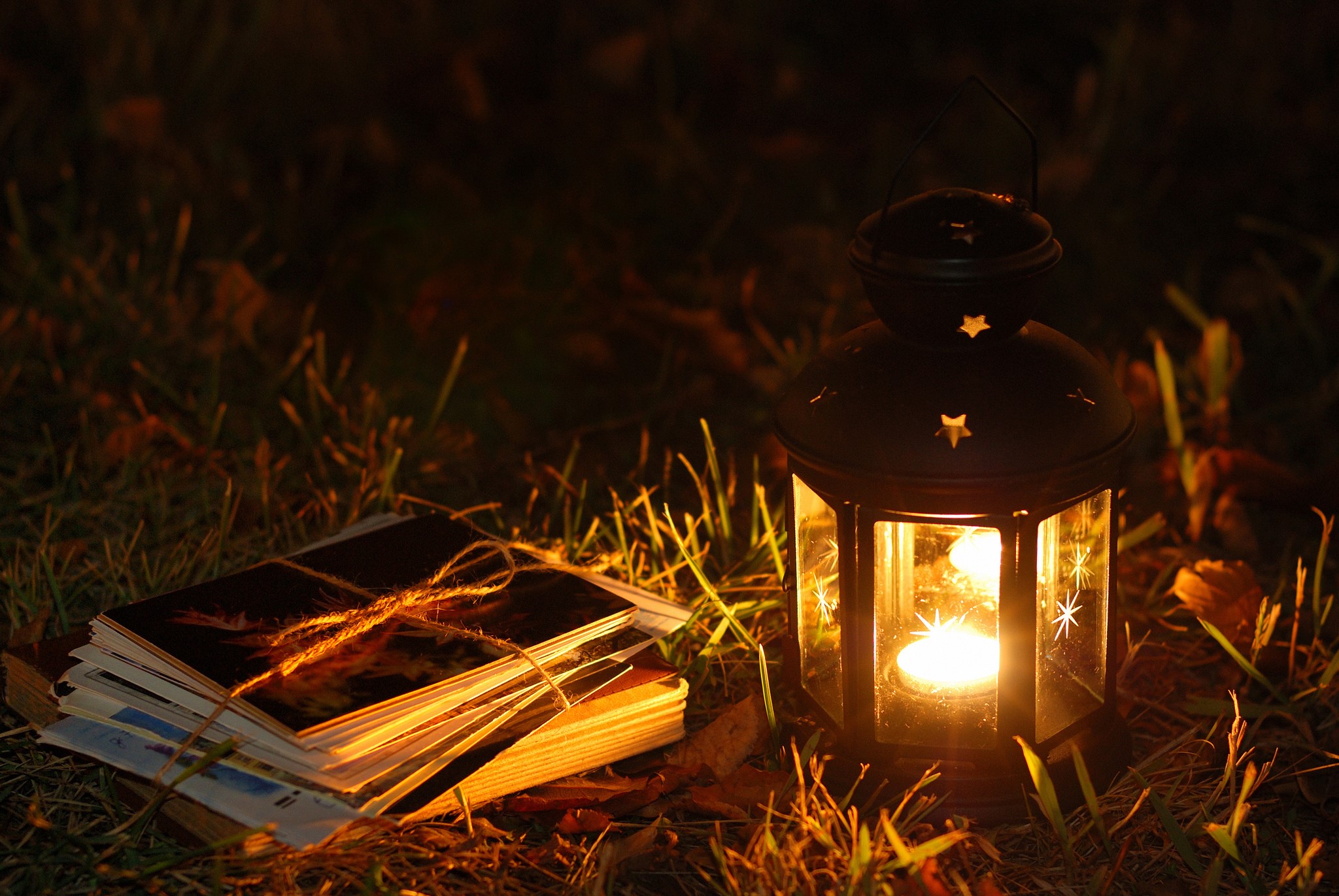 Lantern and photos on grass at night HD Wallpaper