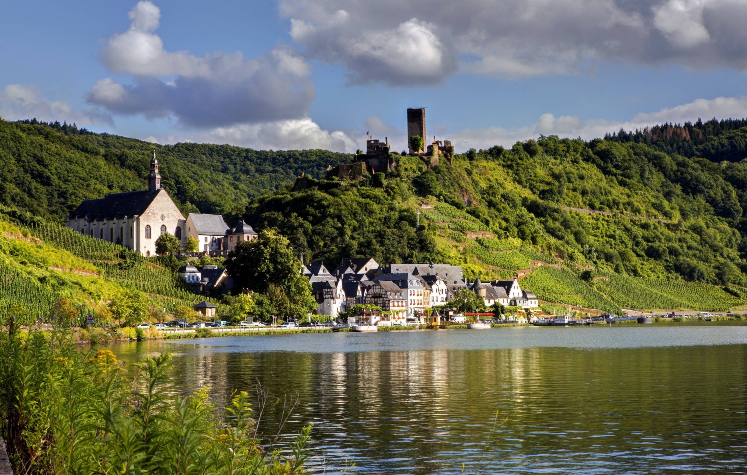 Bruttig-Fankel village with castle ruins on a hill overlooking a river in Germany HD Wallpaper