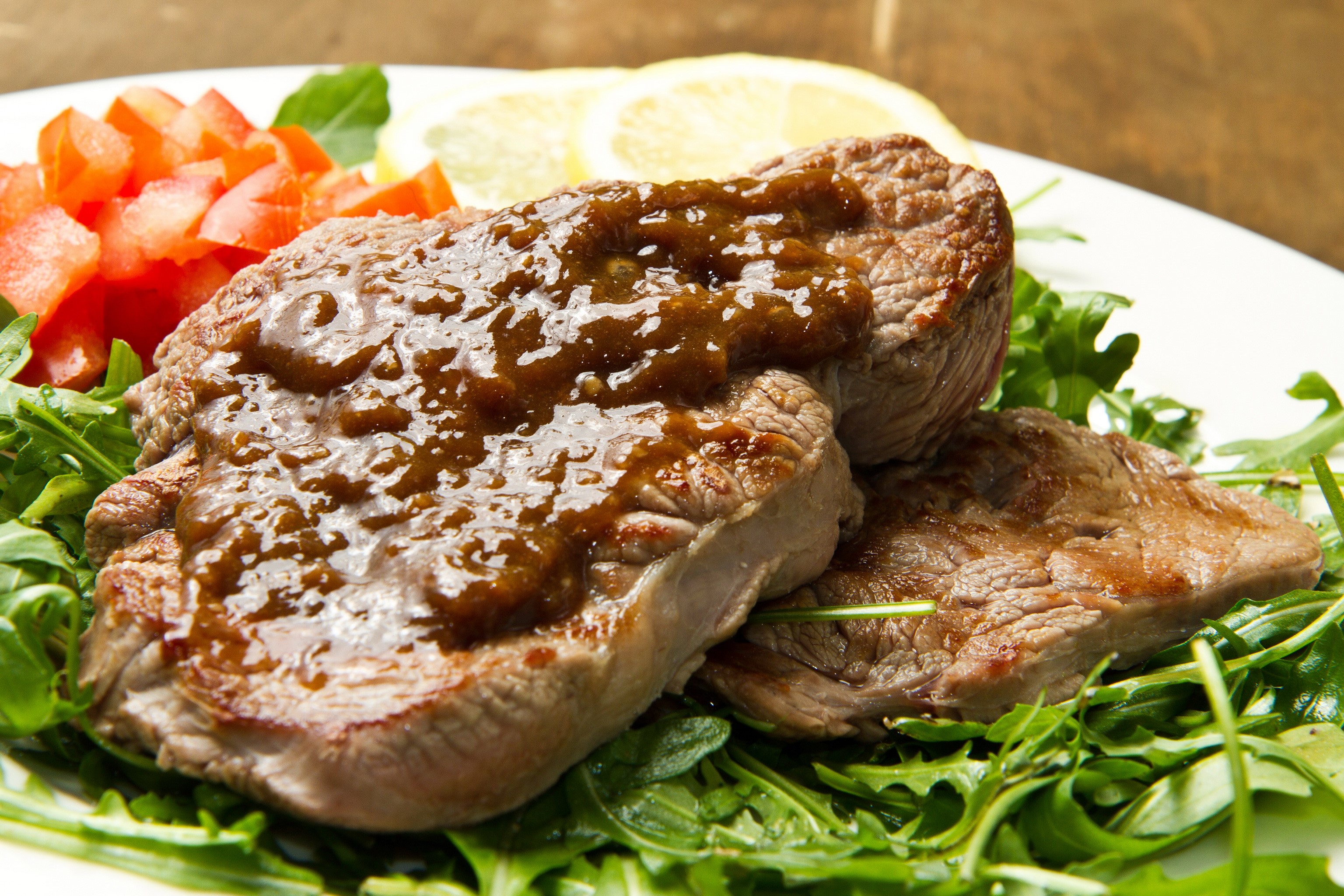 Steak with sauce, tomatoes, and arugula HD Wallpaper