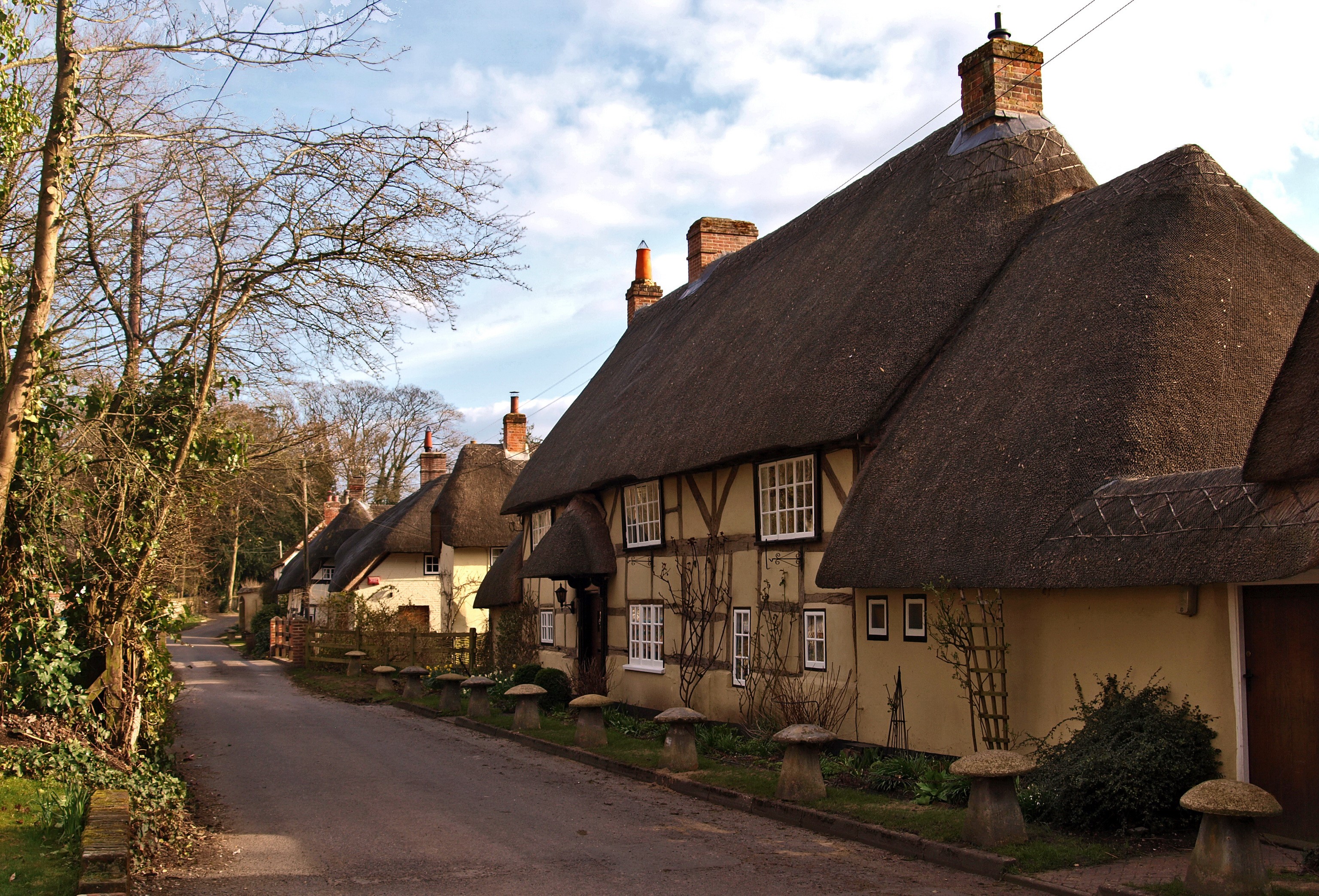 Thatched roof cottages on a village lane in Wherwell, Hampshire, England HD Wallpaper