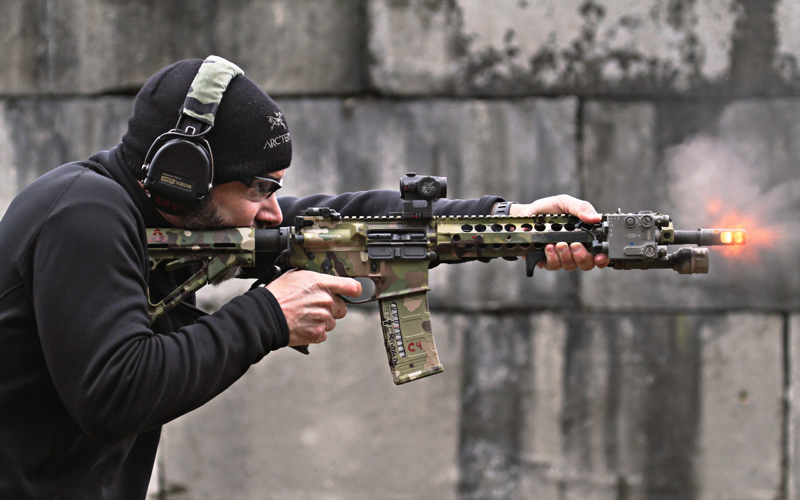Man firing an M4 assault rifle with camouflage stock HD Wallpaper