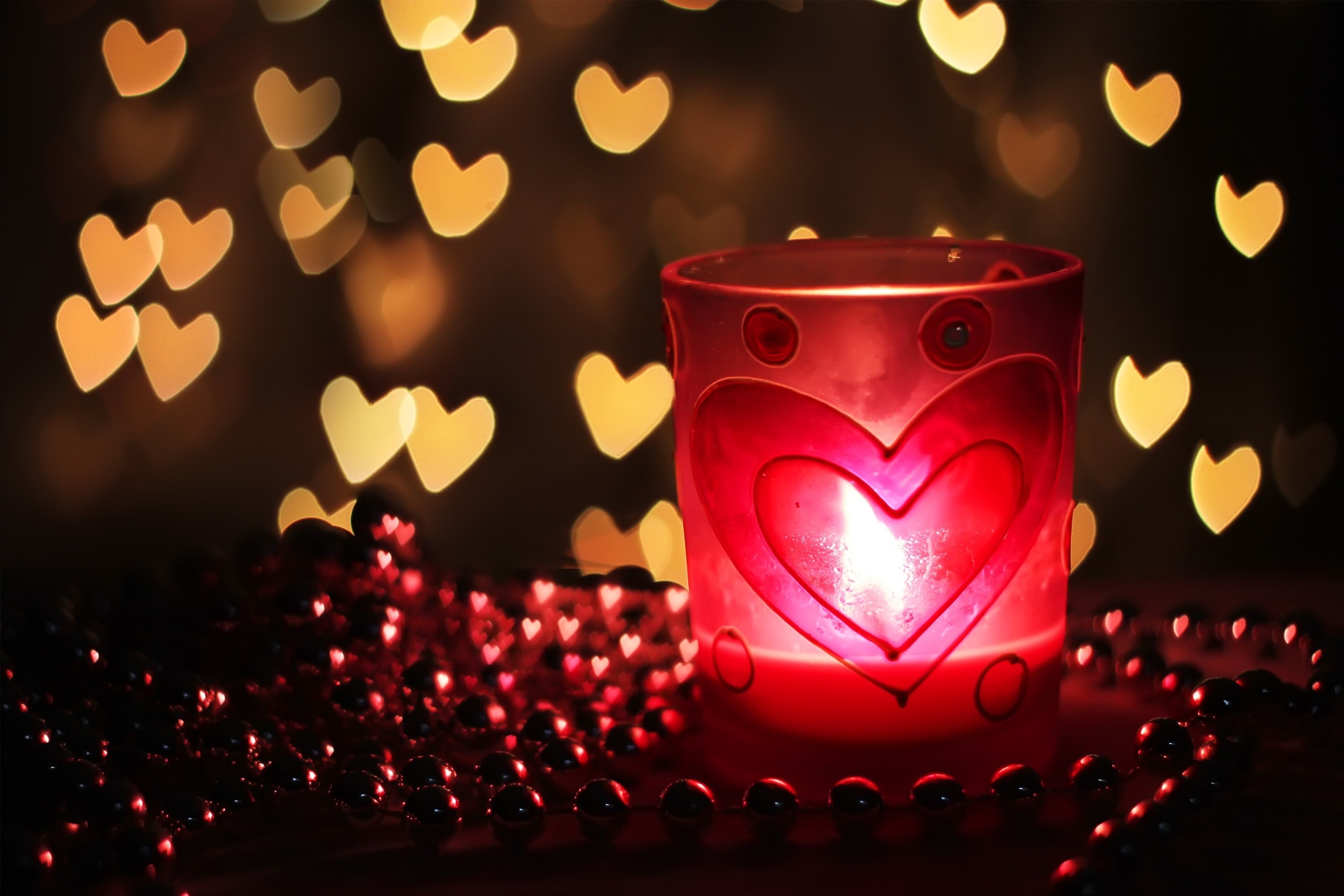 Candle in a heart-decorated glass with heart bokeh HD Wallpaper