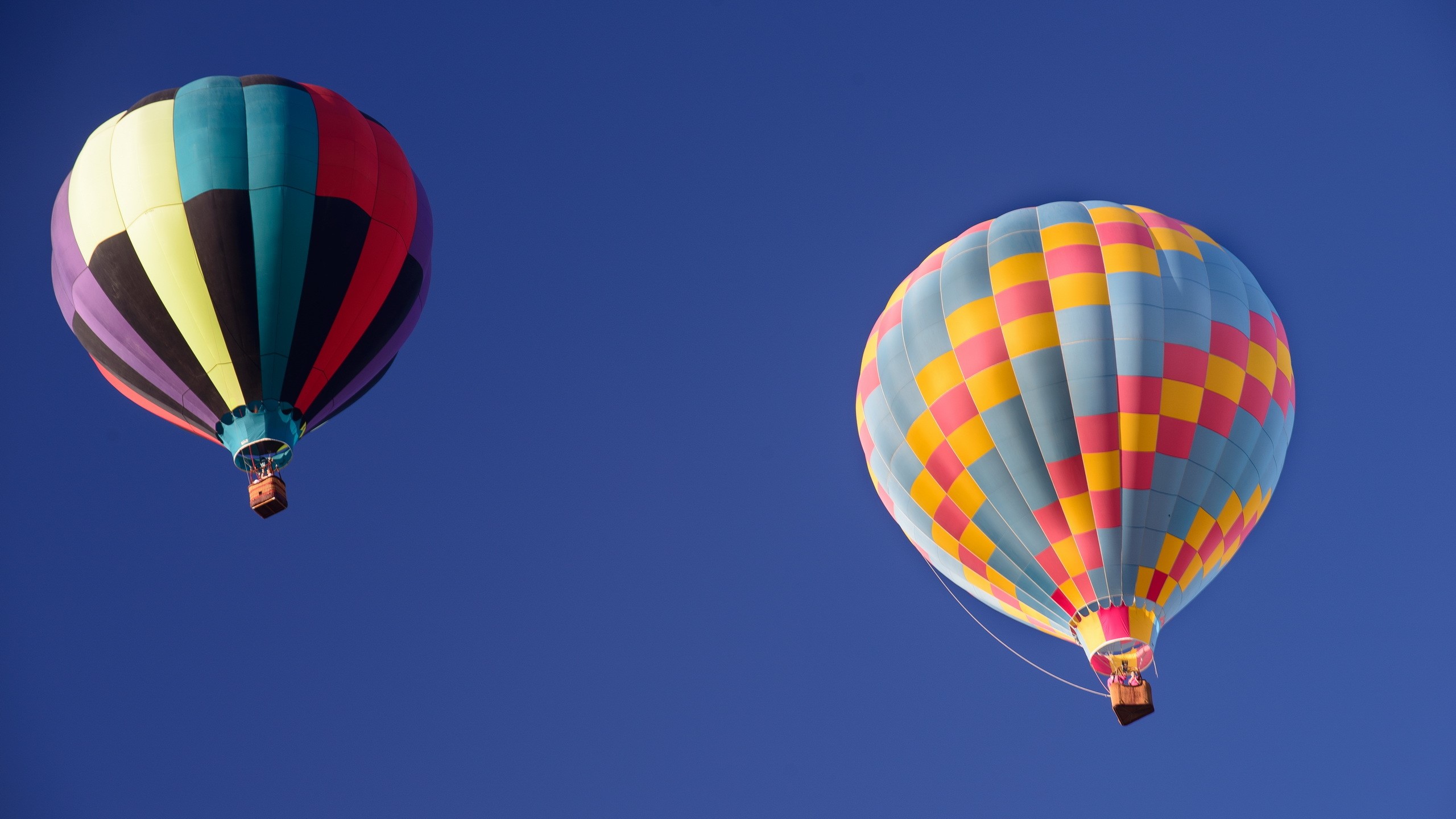 Two hot air balloons flying in a clear blue sky HD Wallpaper