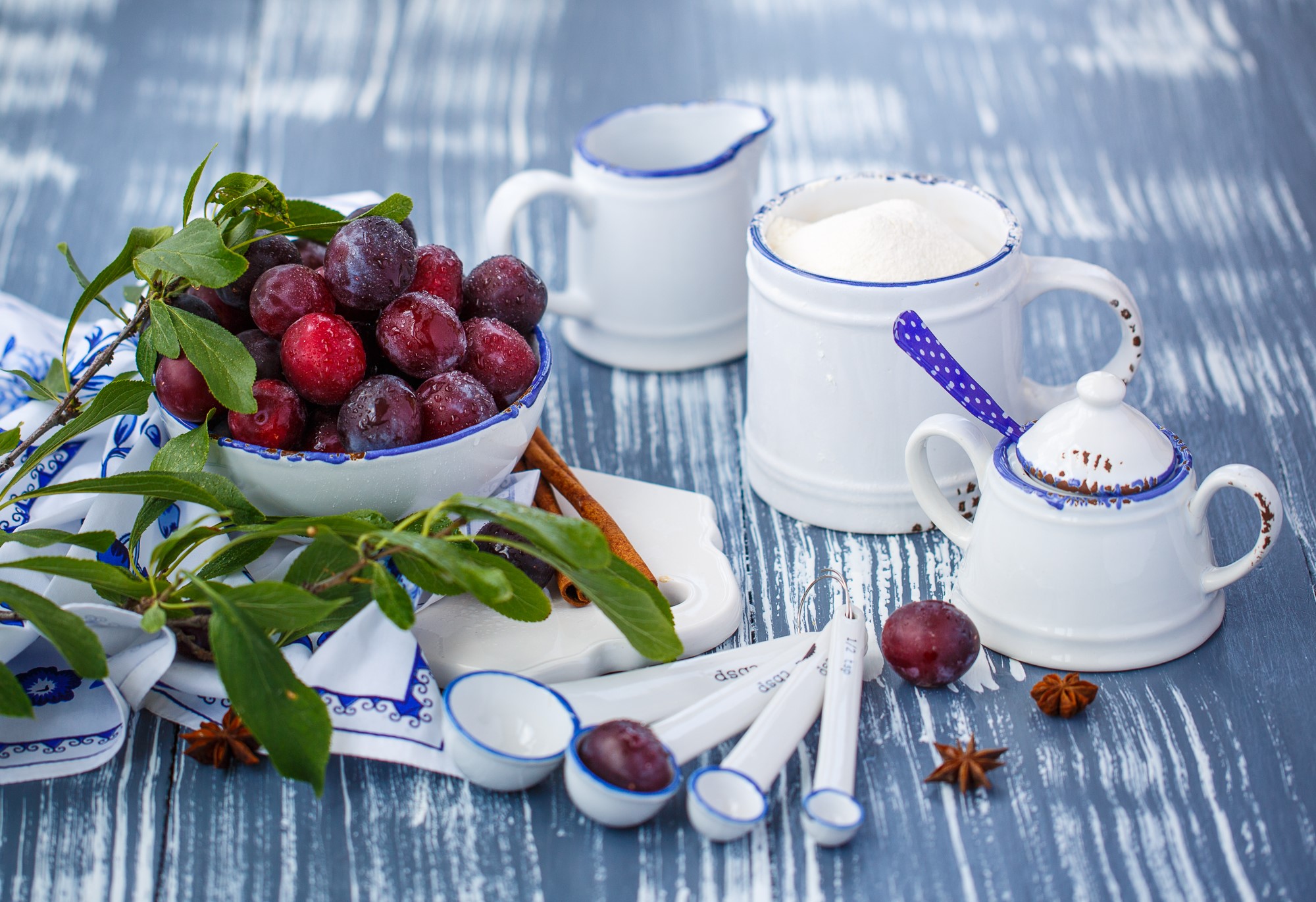 Plums in a bowl with measuring spoons and sugar HD Wallpaper