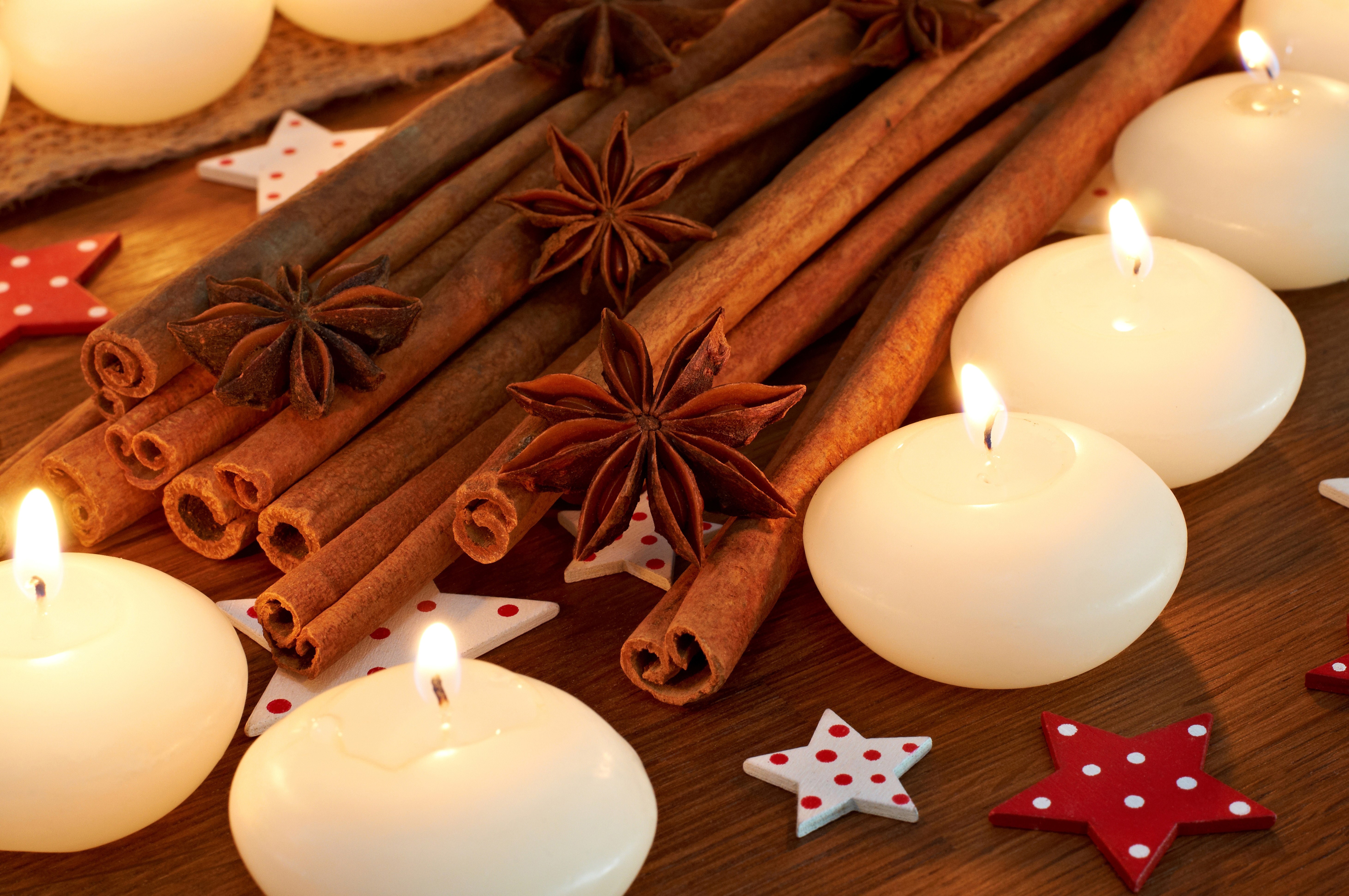 Cinnamon sticks, star anise, and floating candles with stars HD Wallpaper
