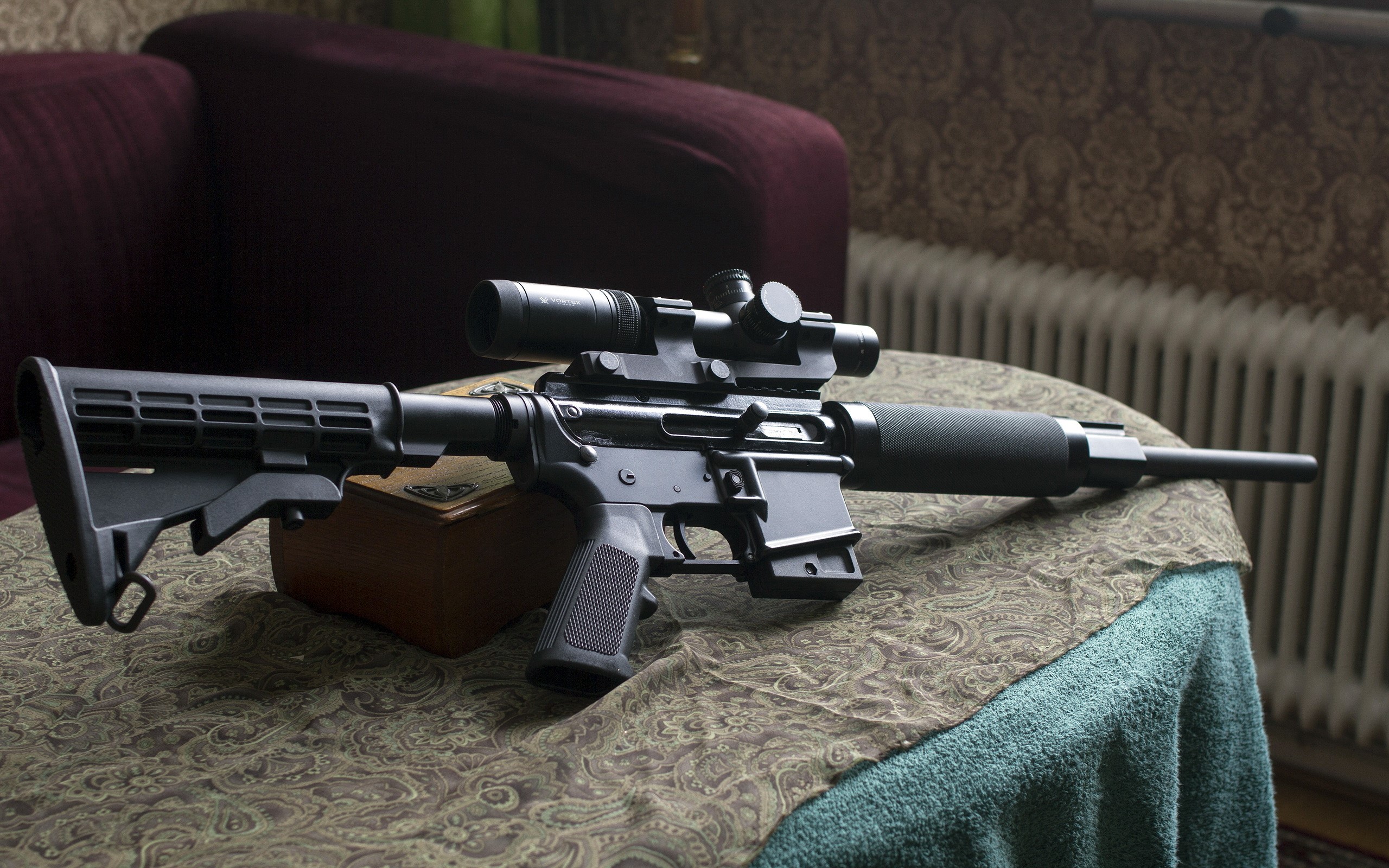 Assault rifle with scope on a table HD Wallpaper