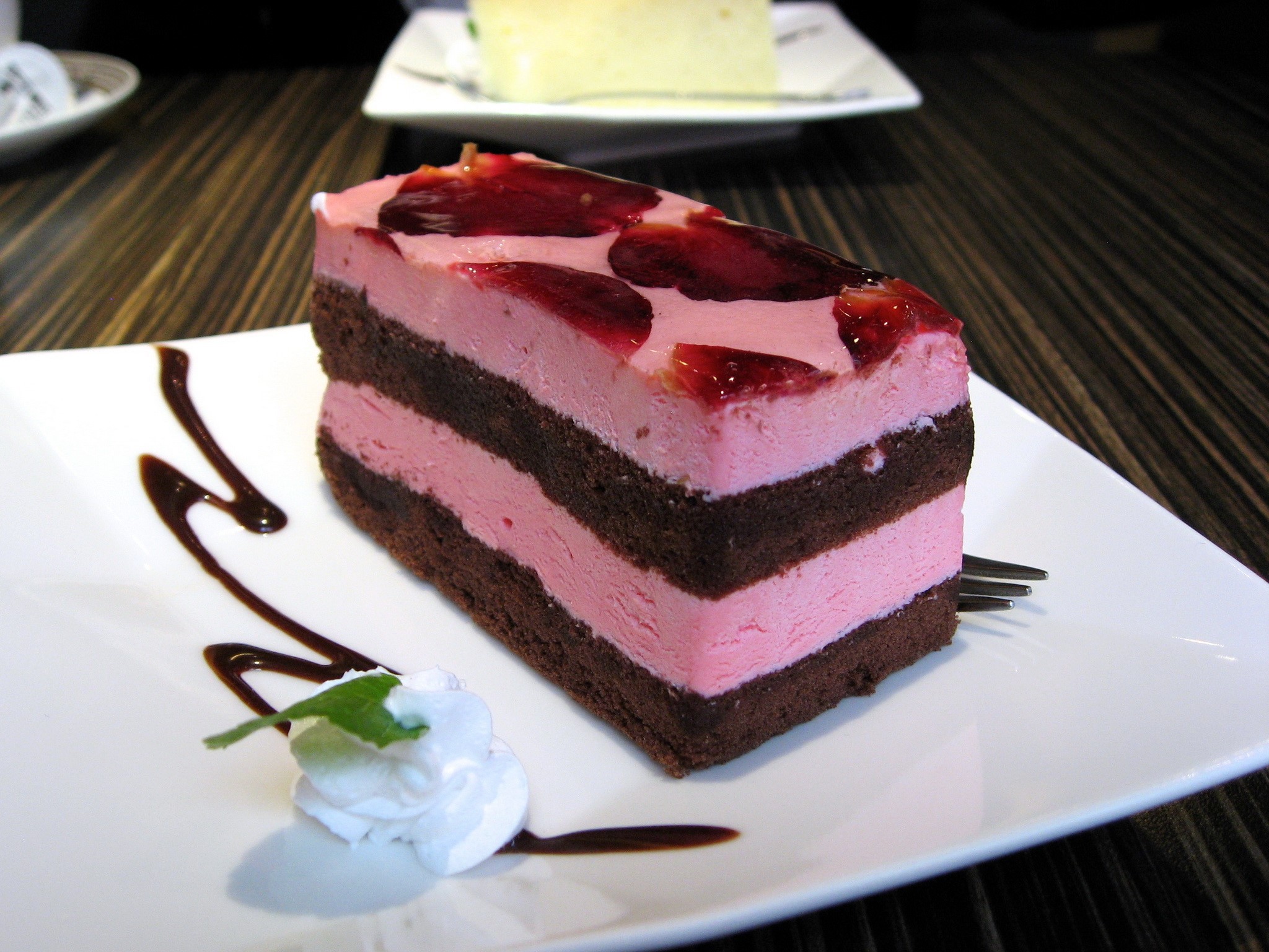 Chocolate cake with pink frosting and fruit topping HD Wallpaper