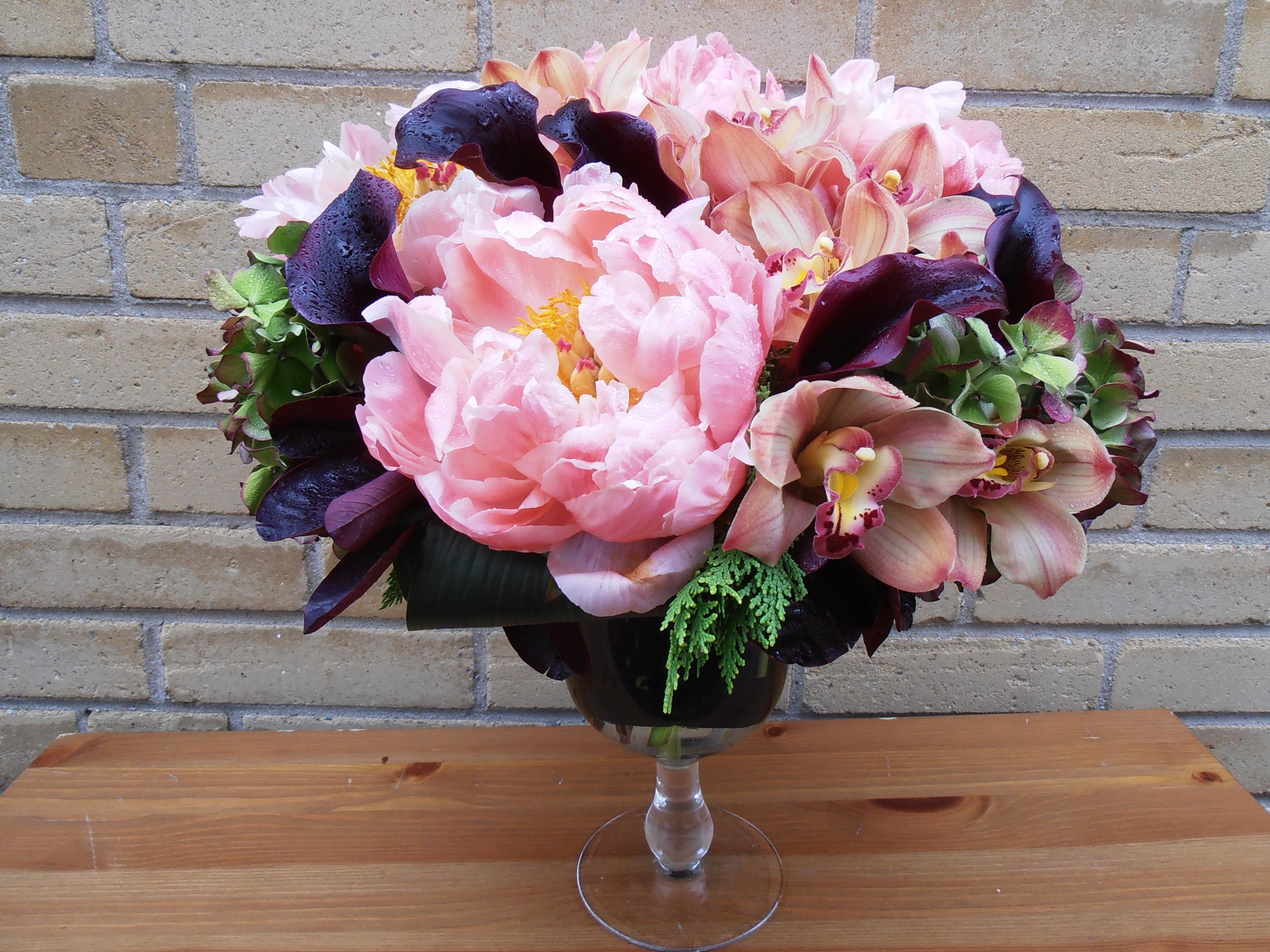 Pink peonies, orchids, calla lilies, and hydrangeas in a glass vase HD Wallpaper