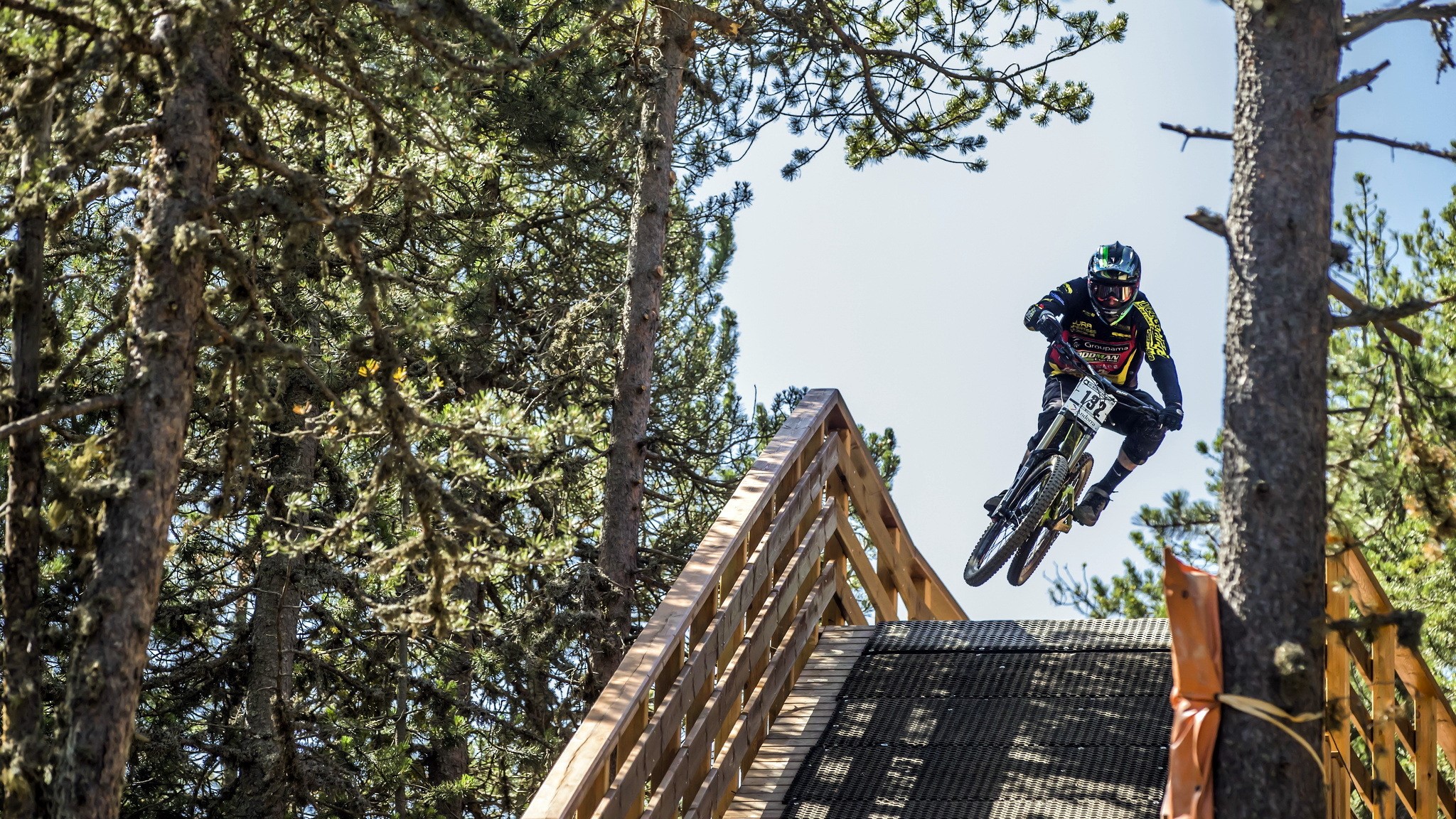 Mountain biker jumping off a wooden ramp HD Wallpaper