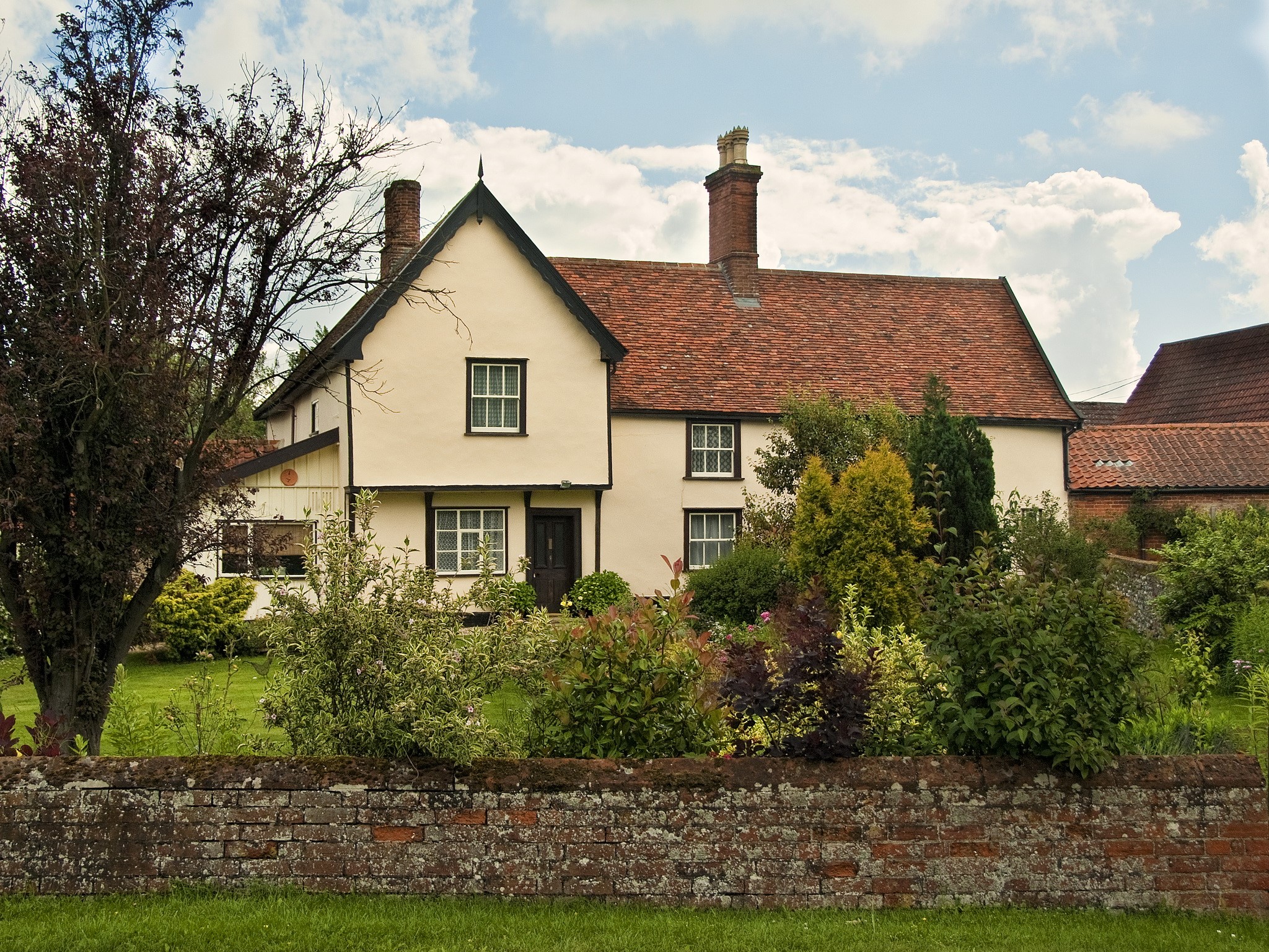 A traditional English cottage with a red tile roof. HD Wallpaper