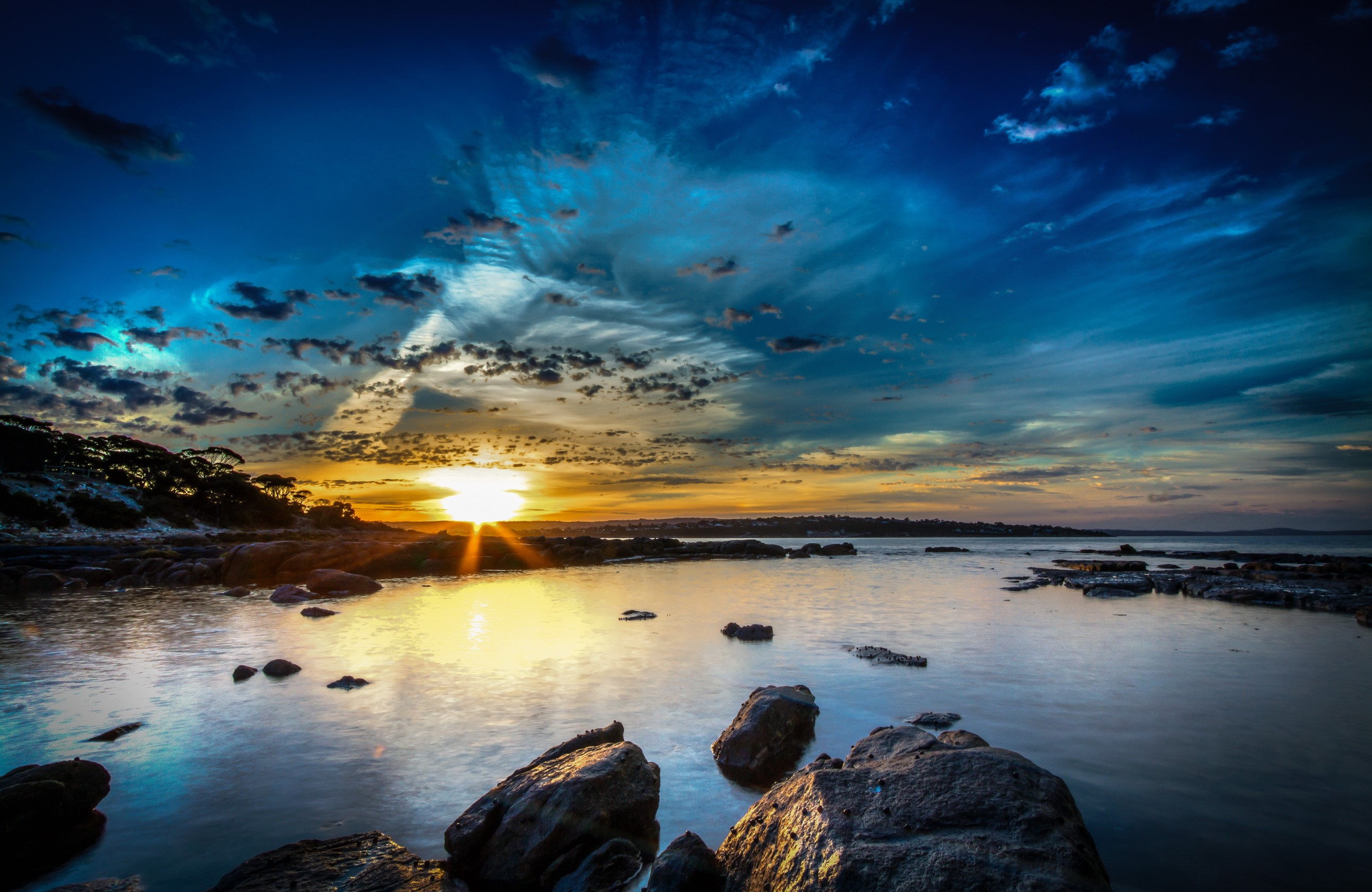 Sunset over rocky coast with dramatic sky HD Wallpaper
