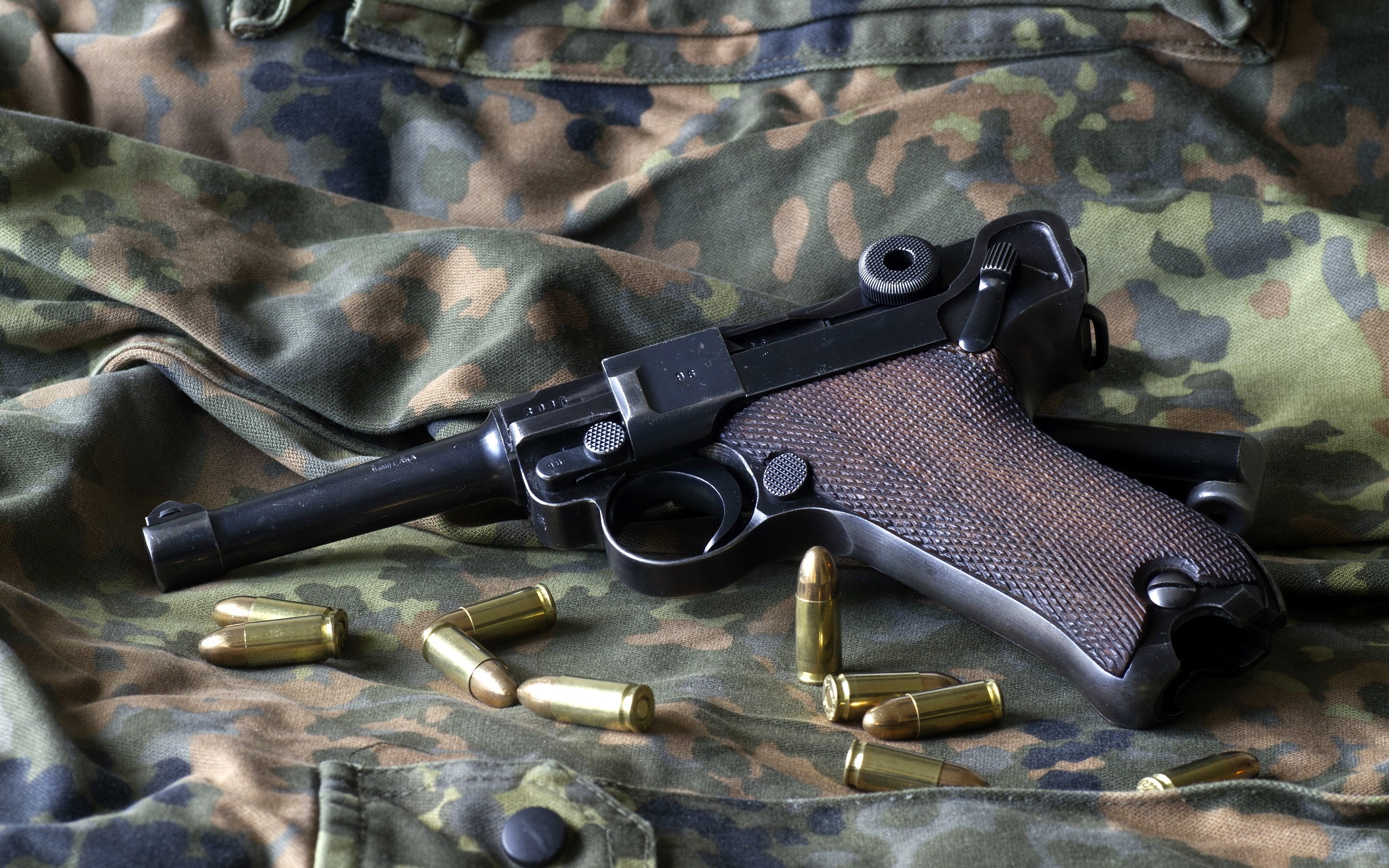 Luger P08 pistol with cartridges on camouflage fabric HD Wallpaper
