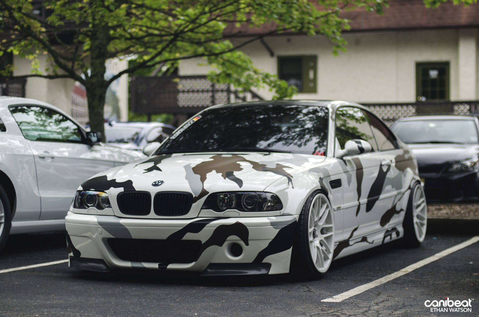 BMW M3 with camouflage wrap parked outdoors HD Wallpaper