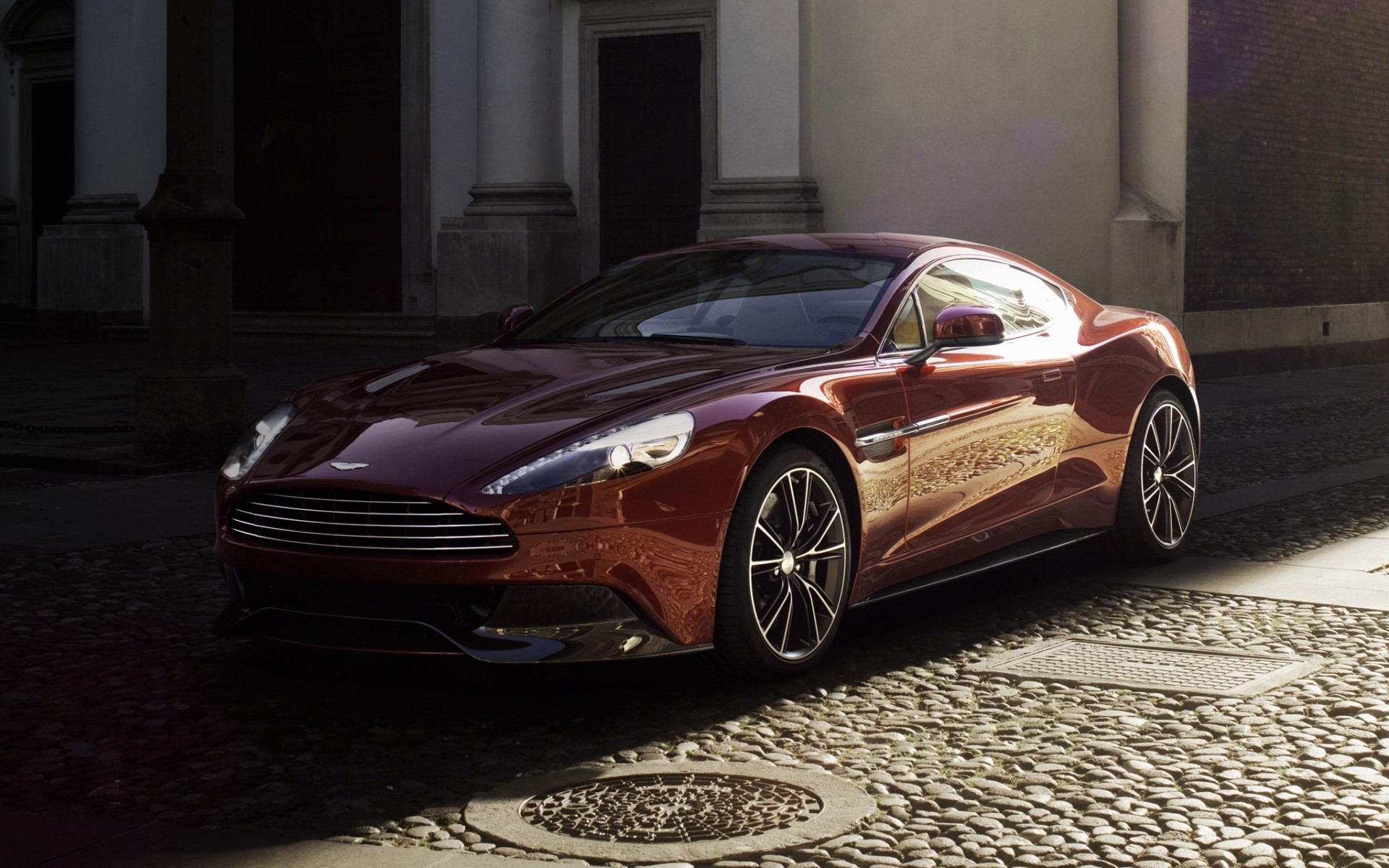 Aston Martin Vanquish in wine color on cobblestone street HD Wallpaper